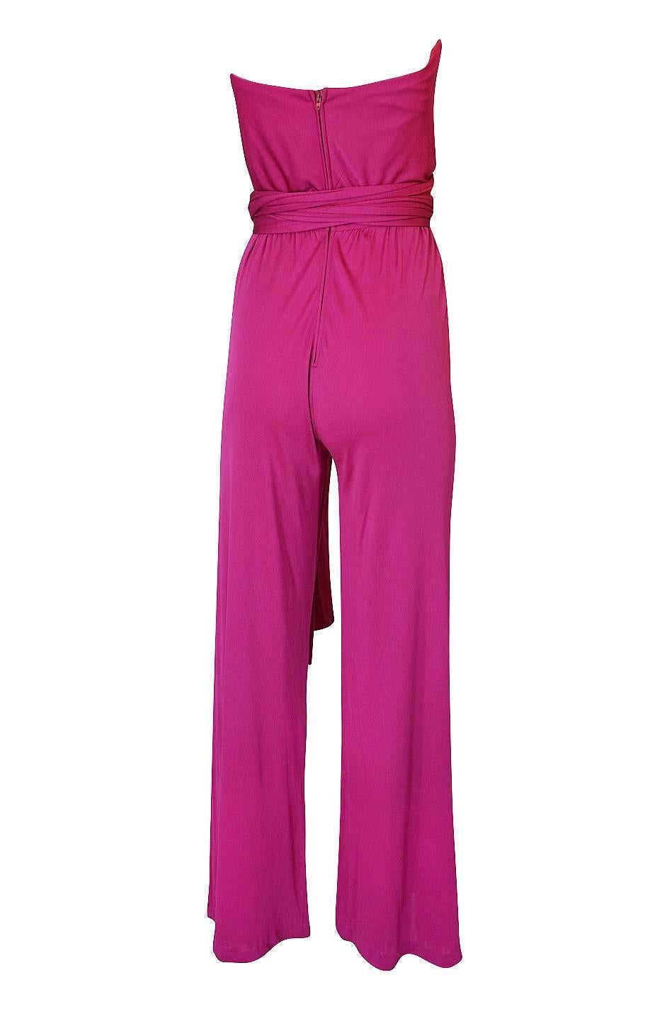 Scott Barrie was known for designing beautiful and sexy clothing. He was particularly adept in the use of silk chiffon and silk jersey, both notoriously difficult fabrics to work with. For this jumpsuit he uses a pink silk jersey and that color is