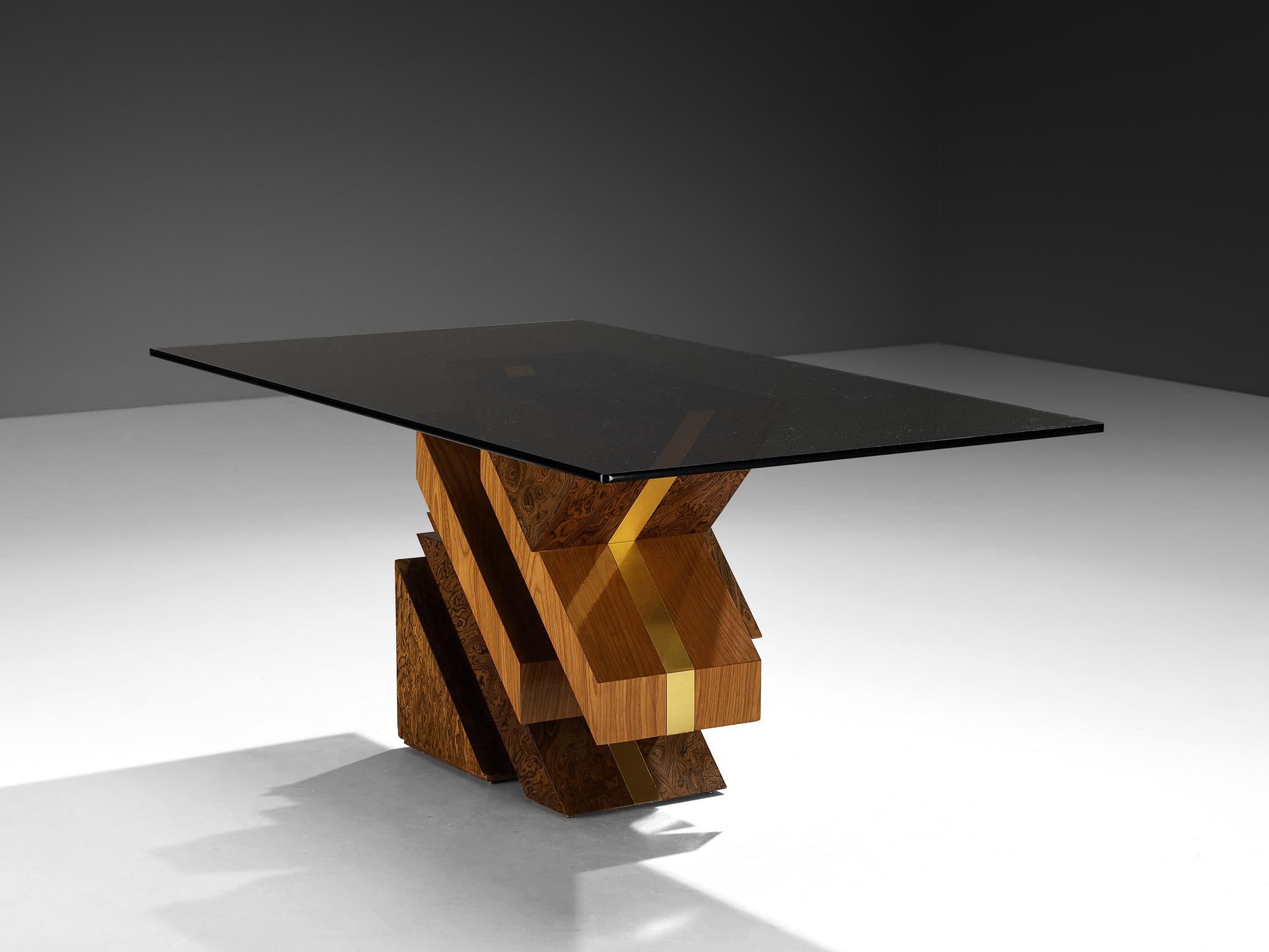 Gagglioli, table de salle à manger, placage de bois Alpi, laiton, verre fumé brun foncé, Rome, Italie, années 1970

Un design postmoderne et anguleux frappant, caractérisé par ses formes géométriques audacieuses et une utilisation extraordinaire des