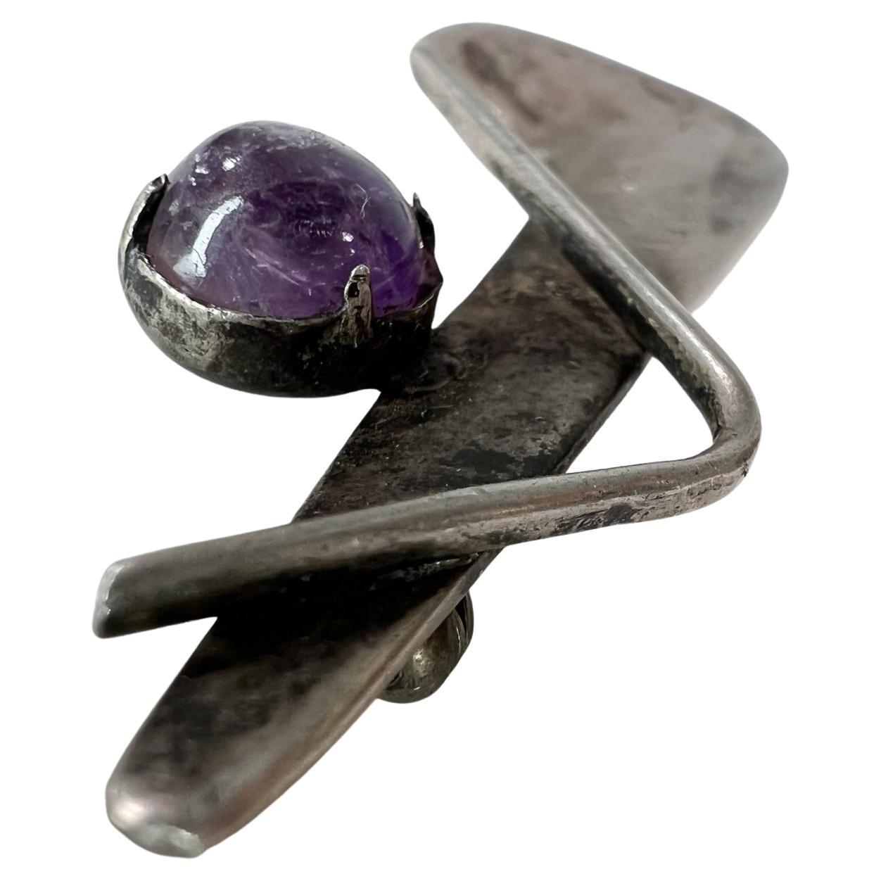 1970s Sculptural Sterling Silver Amethyst Brooch Pin 
Mexican Modernist Taxco Mexico
Stamp present by Miguel Melendez of Los Castillo and Margot designs.
2.38 W x .75 tall x .38 D
Preowned Original Vintage Condition.
Refer to images listed.