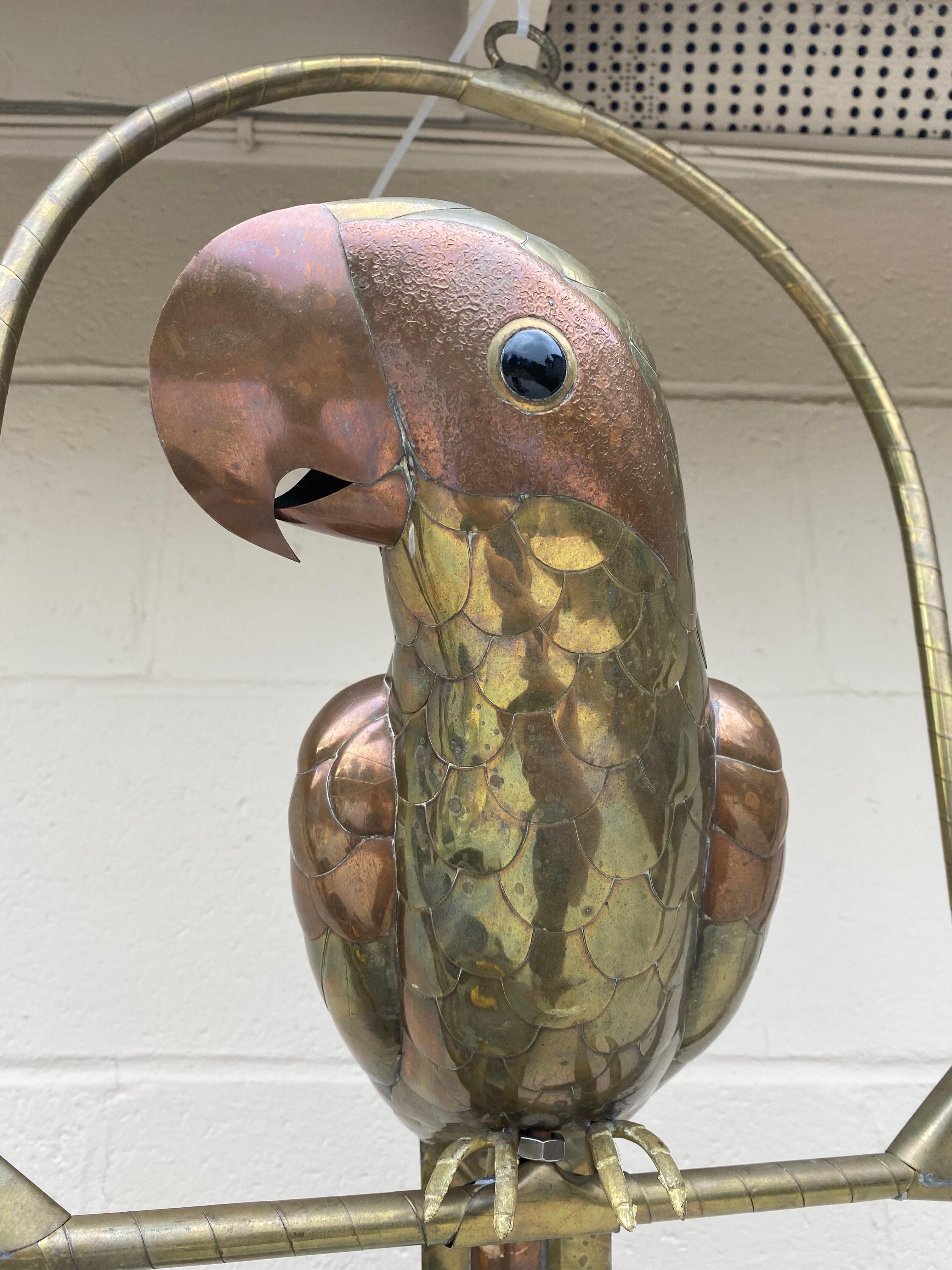 Cool 1970's brass and copper sculpture of a parrot attributed to, or in the style of, Sergio Bustamante. This is a fantastic piece that will bring life to any room displayed. Don't miss out !

This beautiful parrot sits on a swing and is in