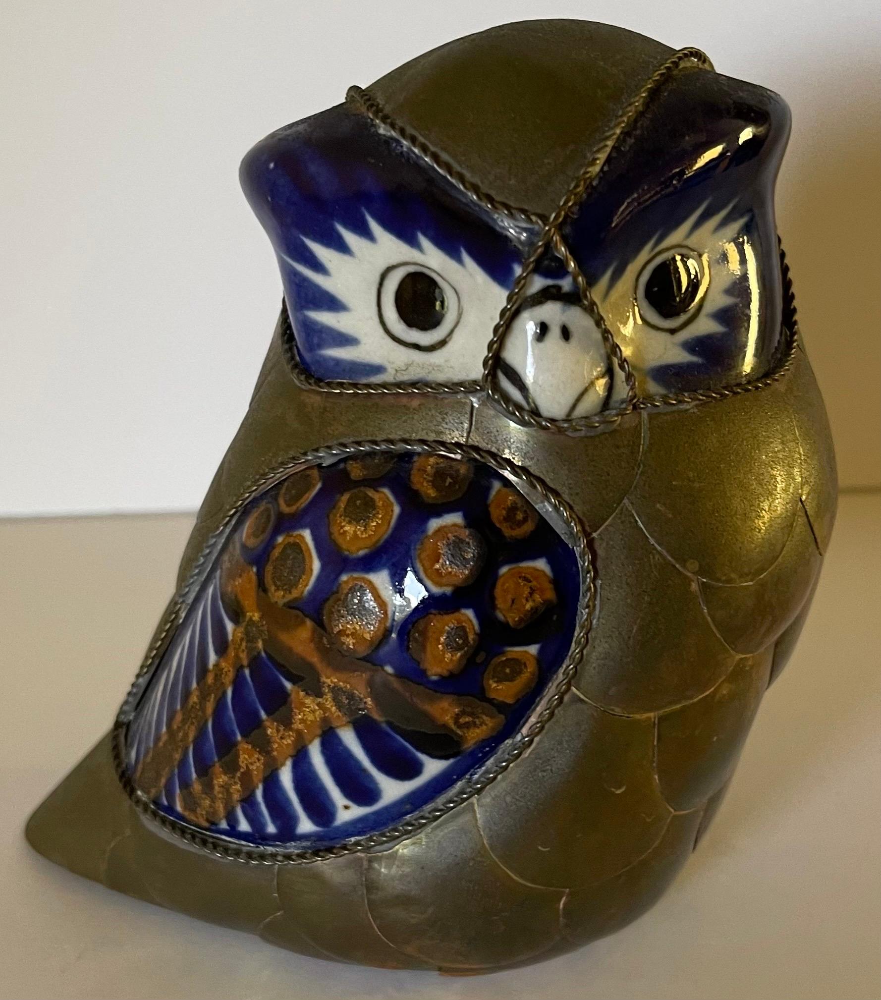 Set of two 1970s brass and ceramic decorative birds. In the style of Sergio Bustamante. Burnished brass with blue/white painted ceramic. No artists signature or brand stamp. 
Owl: 5.5” tall x 5” wide x 3” deep 
Cockatoo: 7” tall x 7” wide x 3” deep 