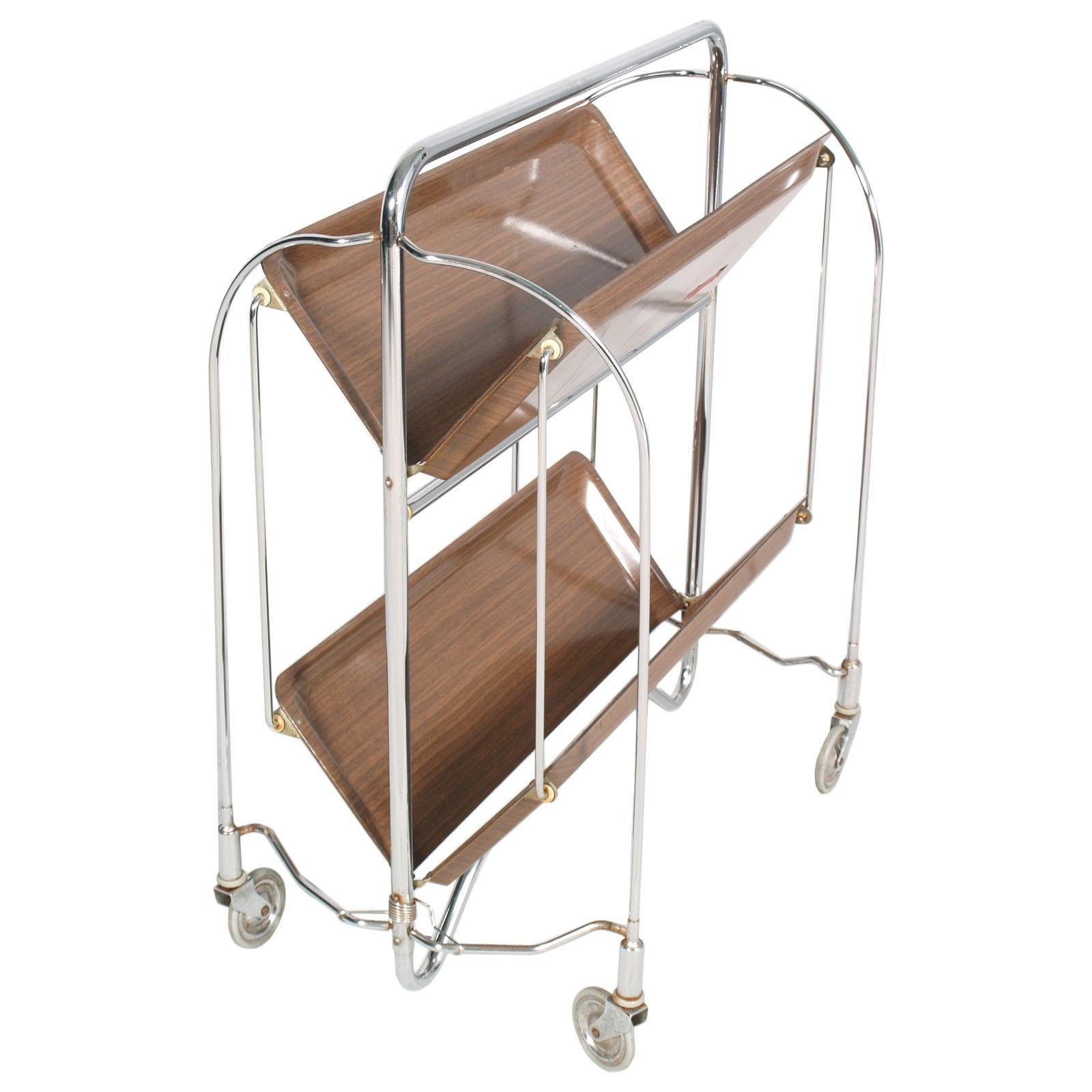 Original vintage bar or serving cart from Germany. Super stylish clean and multifunctional design.
It can be folded and therefore easily stored (great space saver) it can be used as a shelf and as a full serving table on wheels. Versatile stylish
