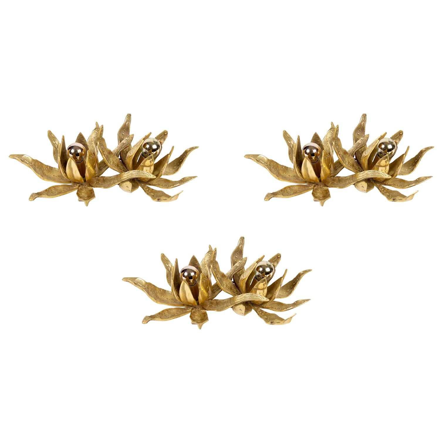 Paul Moerenhout set of three double sconces designed in the 1970s.
Made of solid gilded bronze, the 3 double sconces figure blossoming flowers in a Brutalist manner.
Nice piece of cast bronze.
Each sconces features 2 bulbs.

Measures: Height 32
