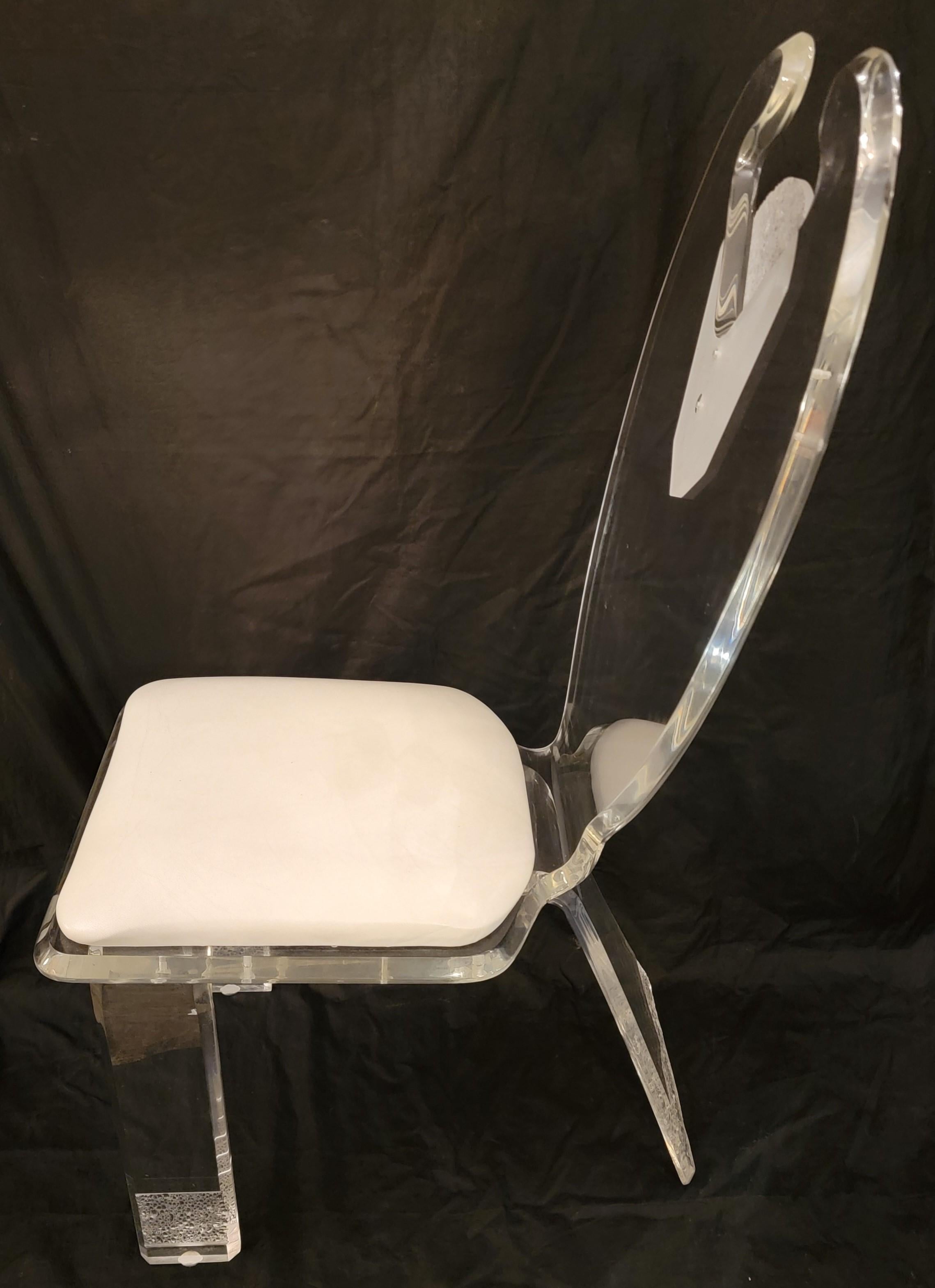 Set of four 1970s ice carved dinning chairs with white leather seats. The bottom of the legs each have a sculpted ice look and have a great aesthetic. The lucite is in great condition.