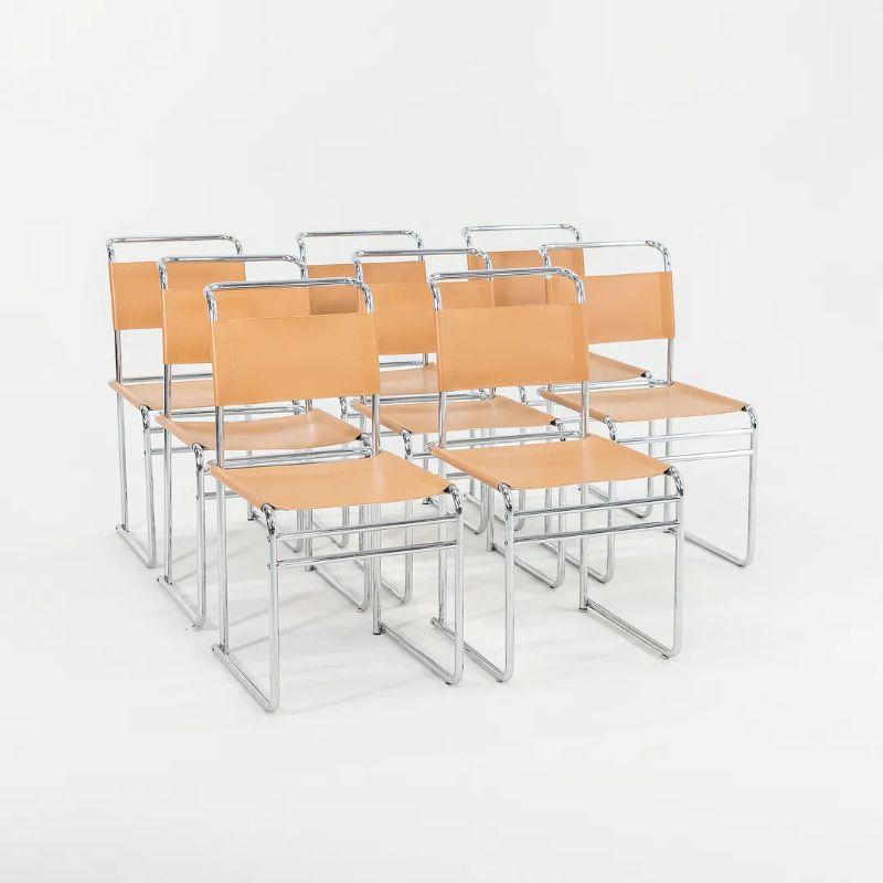 This is a set of 8 Model B5 side chairs, originally designed by Marcel Breuer in 1926. This particular set dates to the 1970s. The listed price includes the set of eight. Their simple design incorporates a tubular bent chromed-steel frame with a tan