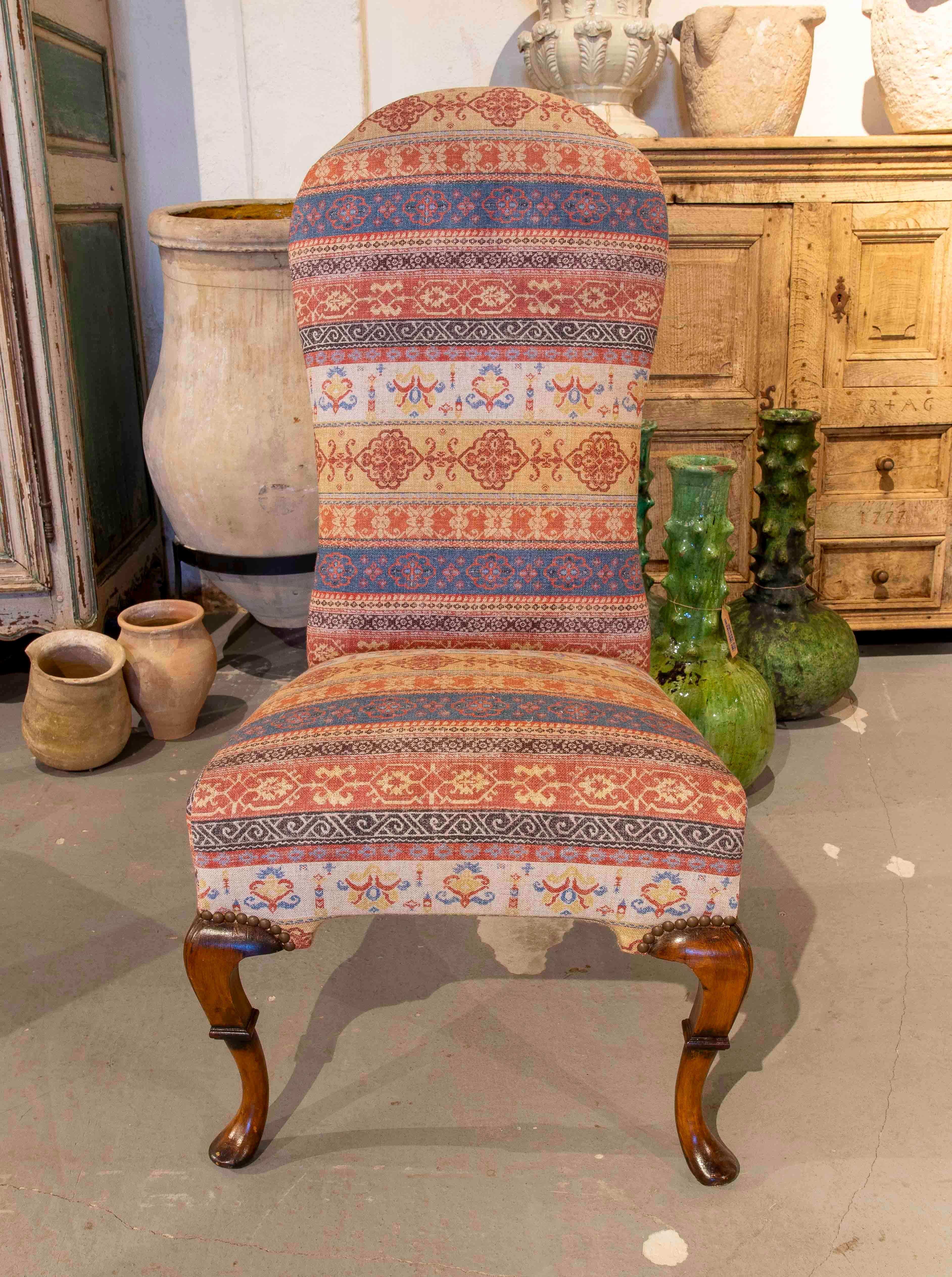 Prächtiges Set aus zehn Hochlehner-Stühlen, bezogen mit einem ethnisch inspirierten Stoff in erdigen Rot-, Blau- und Orangetönen, mit geometrischen und floralen Motiven. Die geschwungenen, lackierten Queen-Anne-Holzbeine sorgen für eine klassische