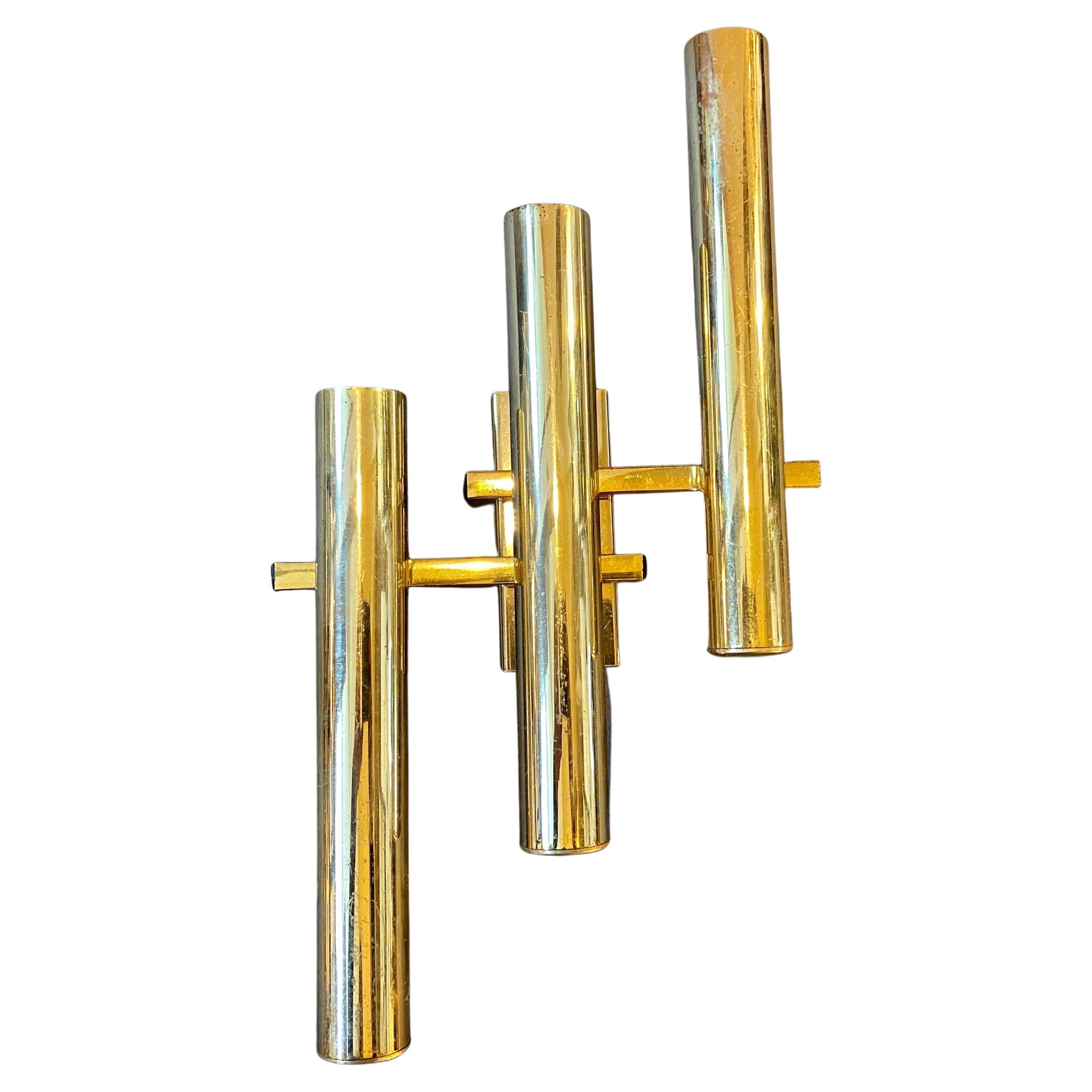 Four iconic brass three lights wall sconces designed by Gaetano Sciolari, manufactured in Italy in the Seventies, brass it's in original patina, they work both 110-240 volts and need three regular e14 bulbs for each sconce.