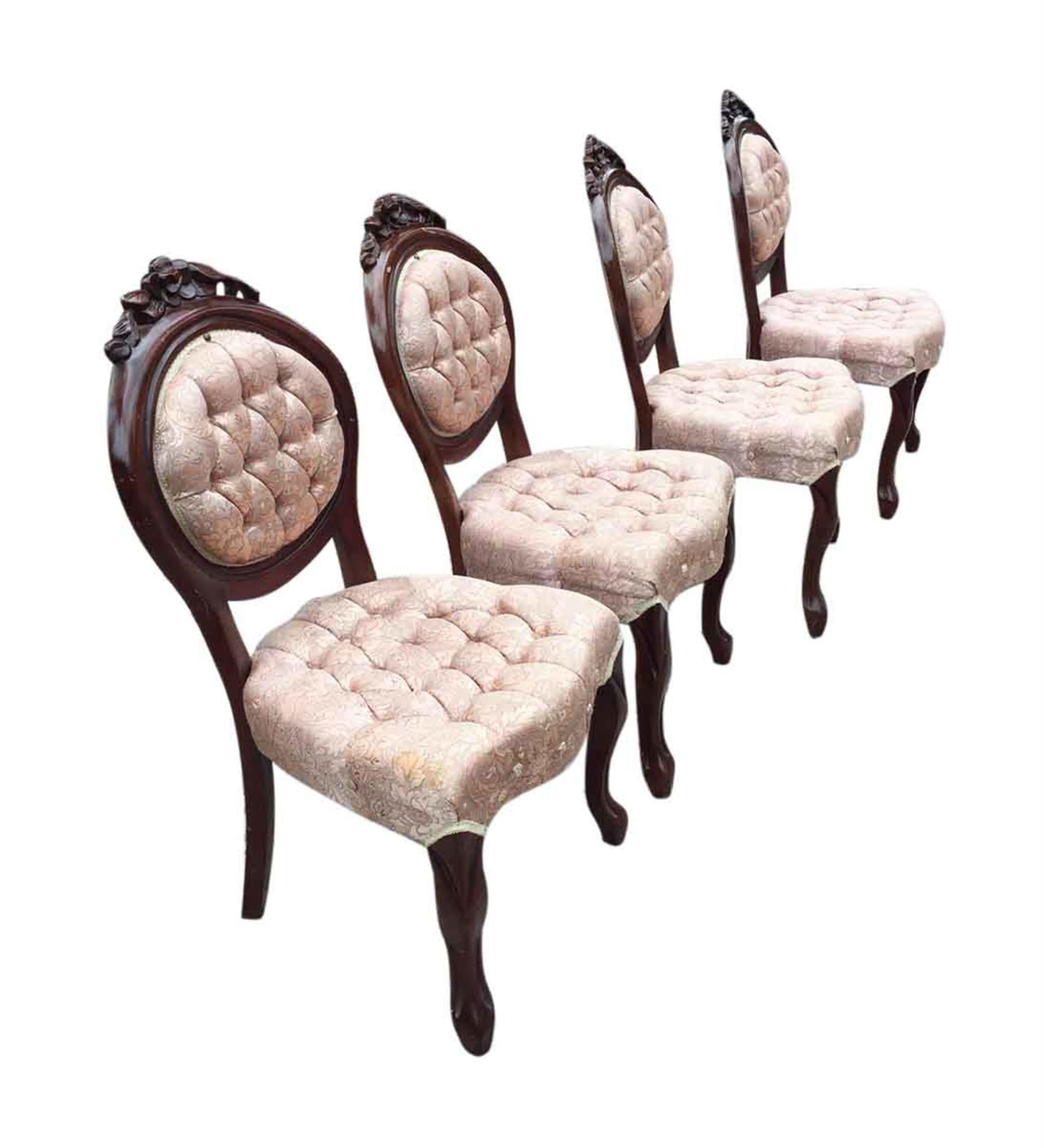 Four 1970s carved dark wood toned French dining room chairs with tufted pink floral silk upholstery, brass rivets, and floral detail in the frame. Priced as a set. This can be seen at our 2420 Broadway location on the upper west side in Manhattan.