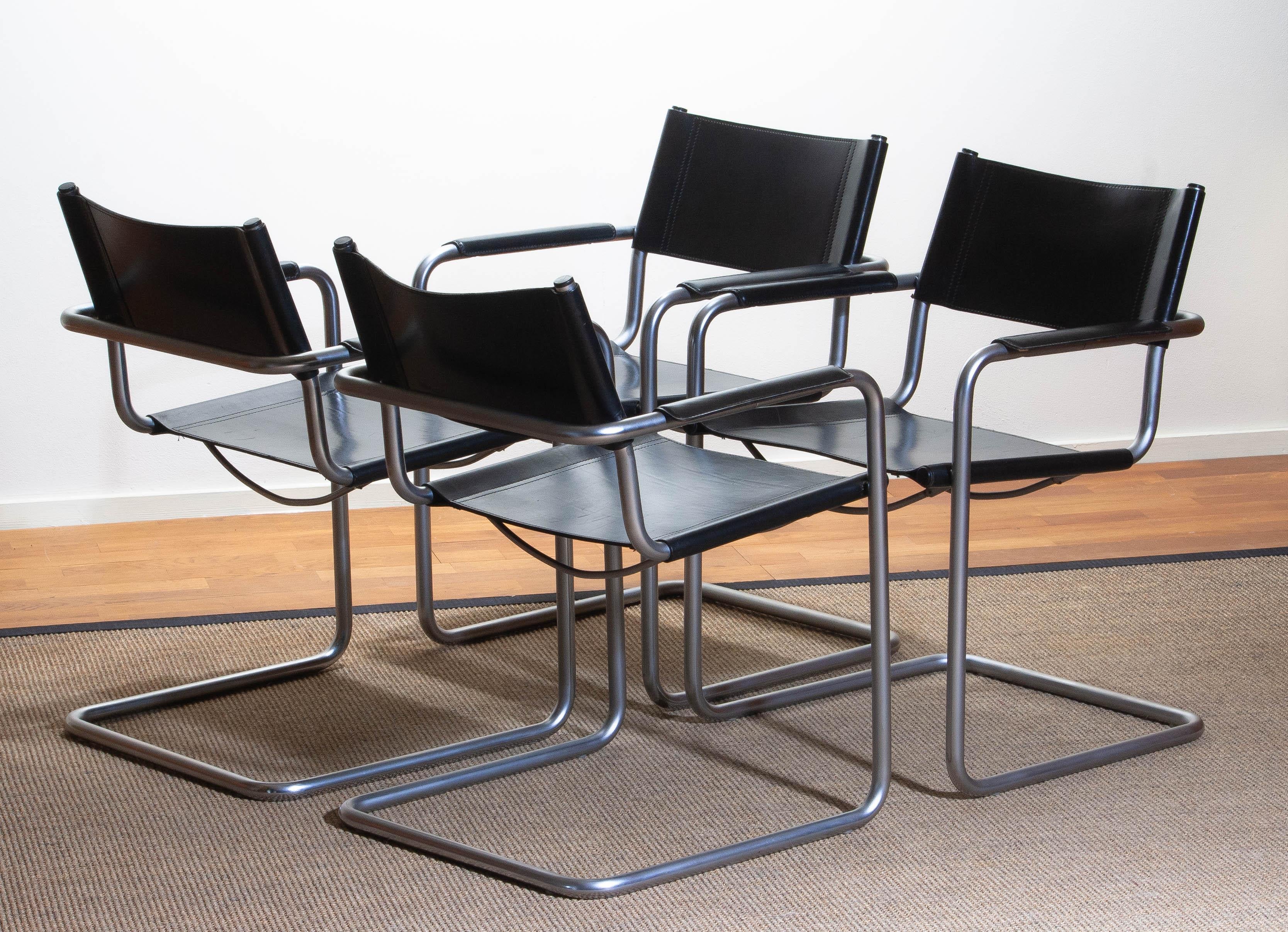 1970, perfect set of four dining or office chairs made by Matteo Grassi, Italy. 
The chairs have tubular titanium look steel frames with sturdy black leather seating and backrest. 
They are signed on the back of the backrest. 
Overall condition