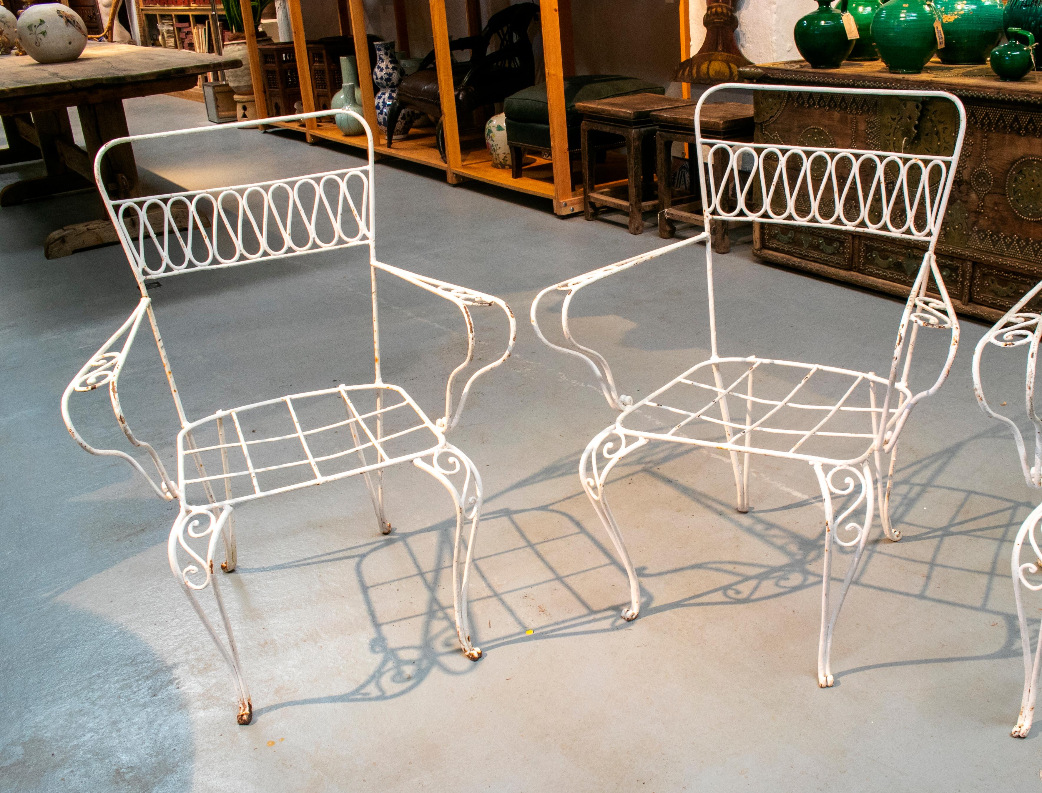 1970s set of four Spanish white painted iron garden chairs.