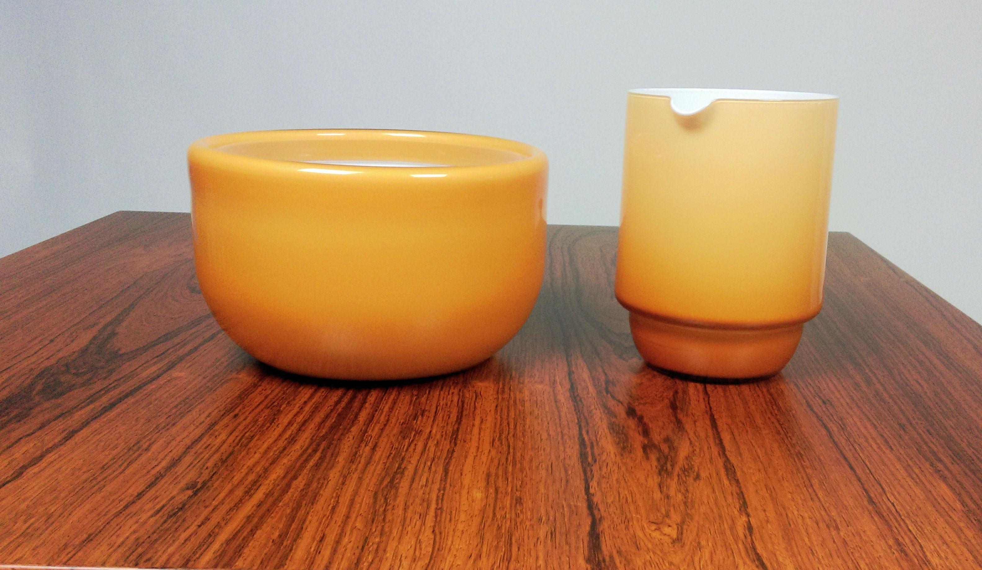 Set of pitcher and bowl in yellow glass designed by Michael Bang and produced by Holmegaard in the 1970s.

The set is in excellent condition.

Seize in cm. / in.:
Bowl
H: 11.5 / 4,5., D: 19 / 7.5
Pitcher
H: 15 / 5.9, D: 11 / 4.3
 