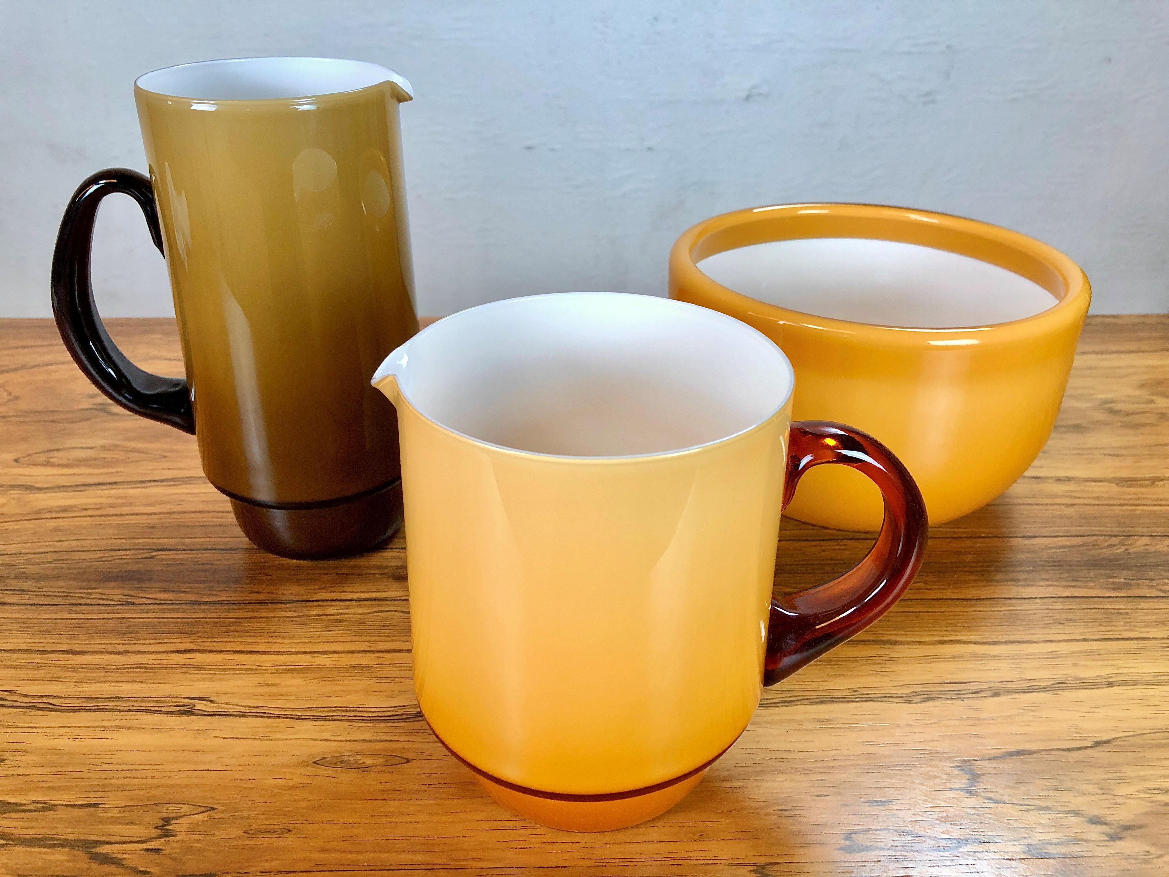 Set of two pitchers and a bowl in dusty yellow, designed by Michael Bang and produced by Holmegaard in the 1970s.

The well designed set with it´s 1970´s colors is in very good condition.

Michael Bang (1942-2013) was the son of Jacob E. Bang,