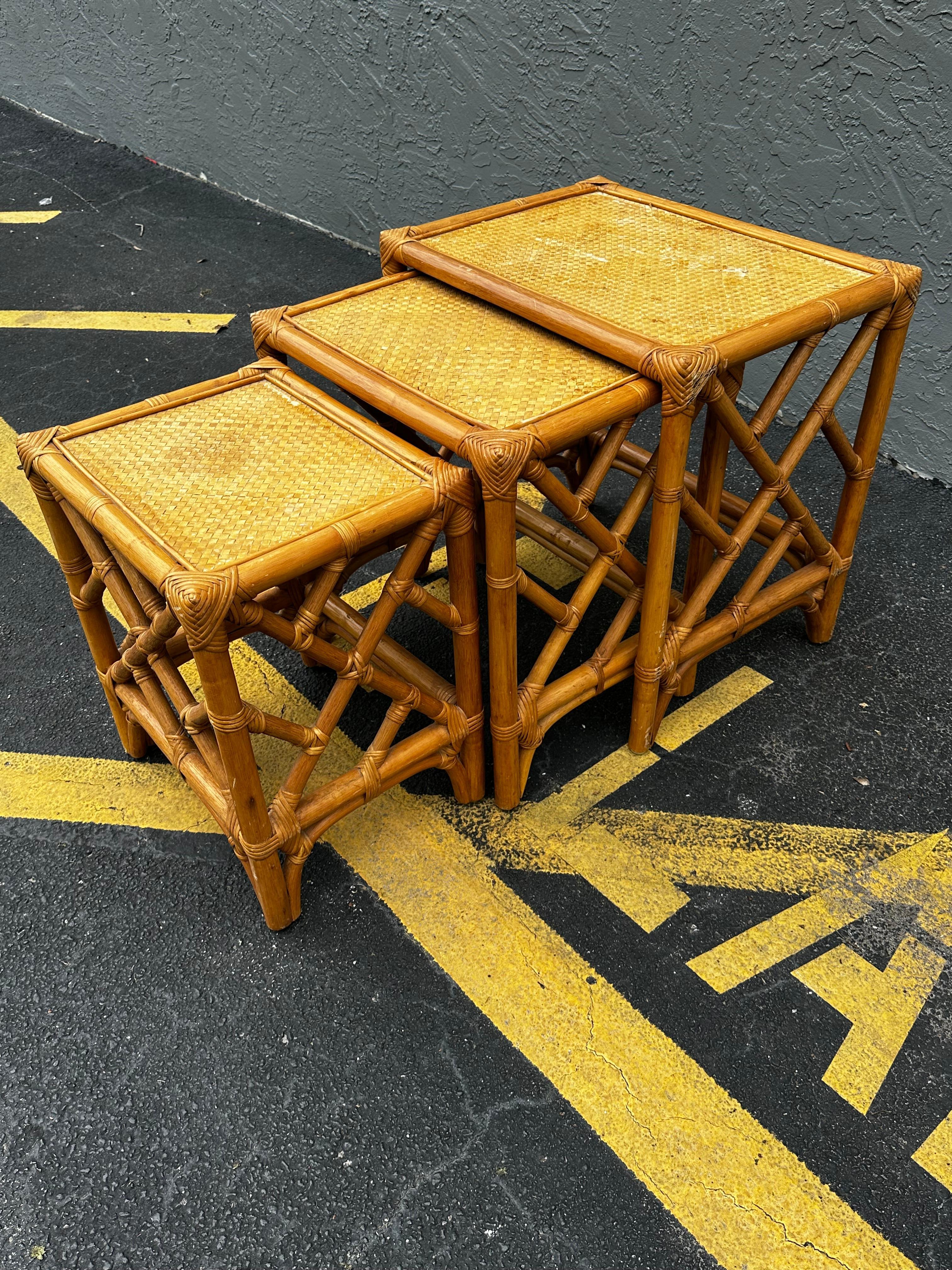 Magnifique ensemble de trois tables d'appoint en rotin, dont le plateau est orné d'une toile de gazon en raphia.
Fabriqué par McGuire dans le style moderne organique californien. Construit à partir de perches de rotin reliées entre elles par des