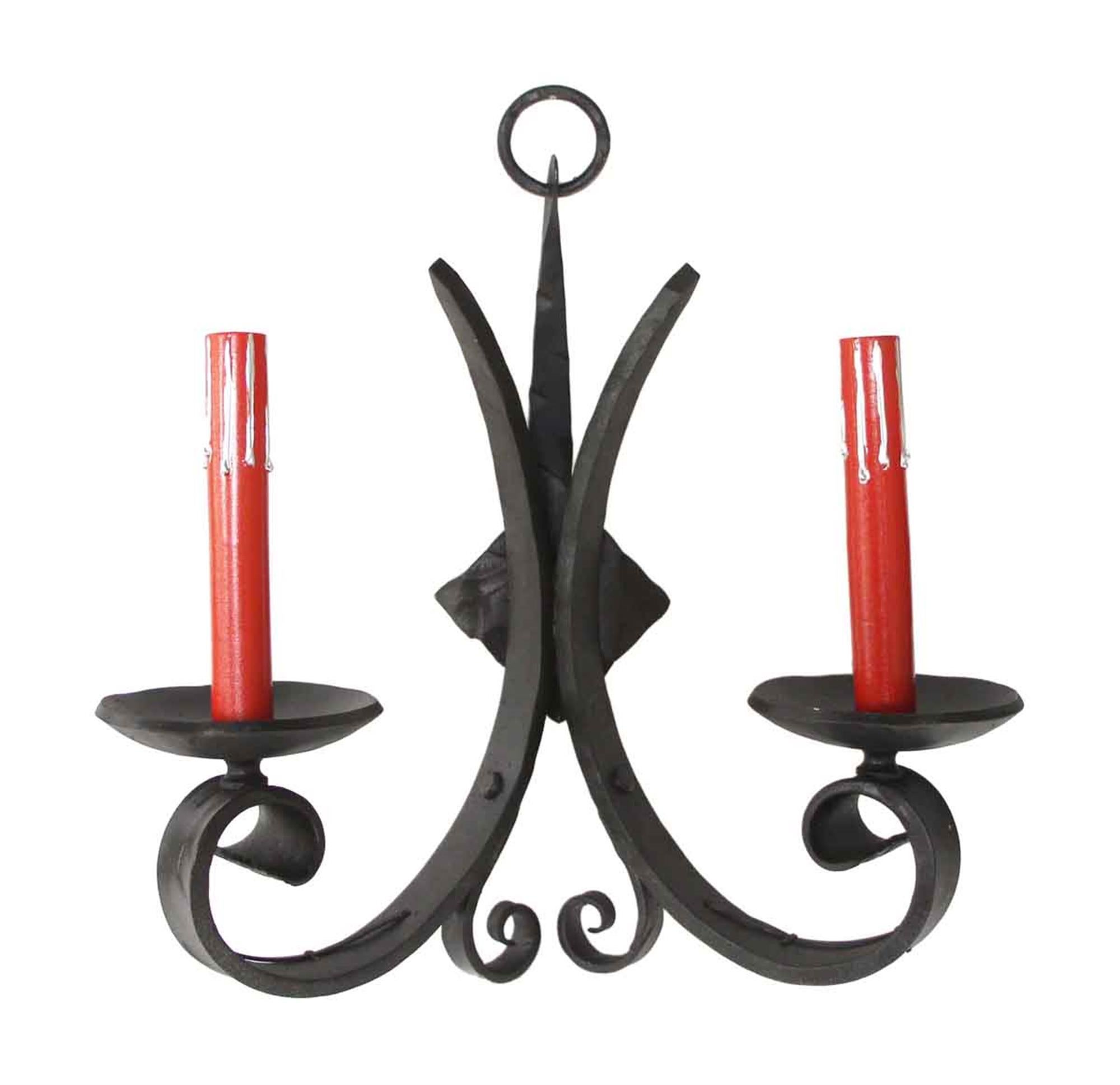 1970s wrought iron black two arm Gothic style sconces with red candlesticks. Priced as a set. This can be viewed at our Los Angeles location. Please inquire for the exact address.