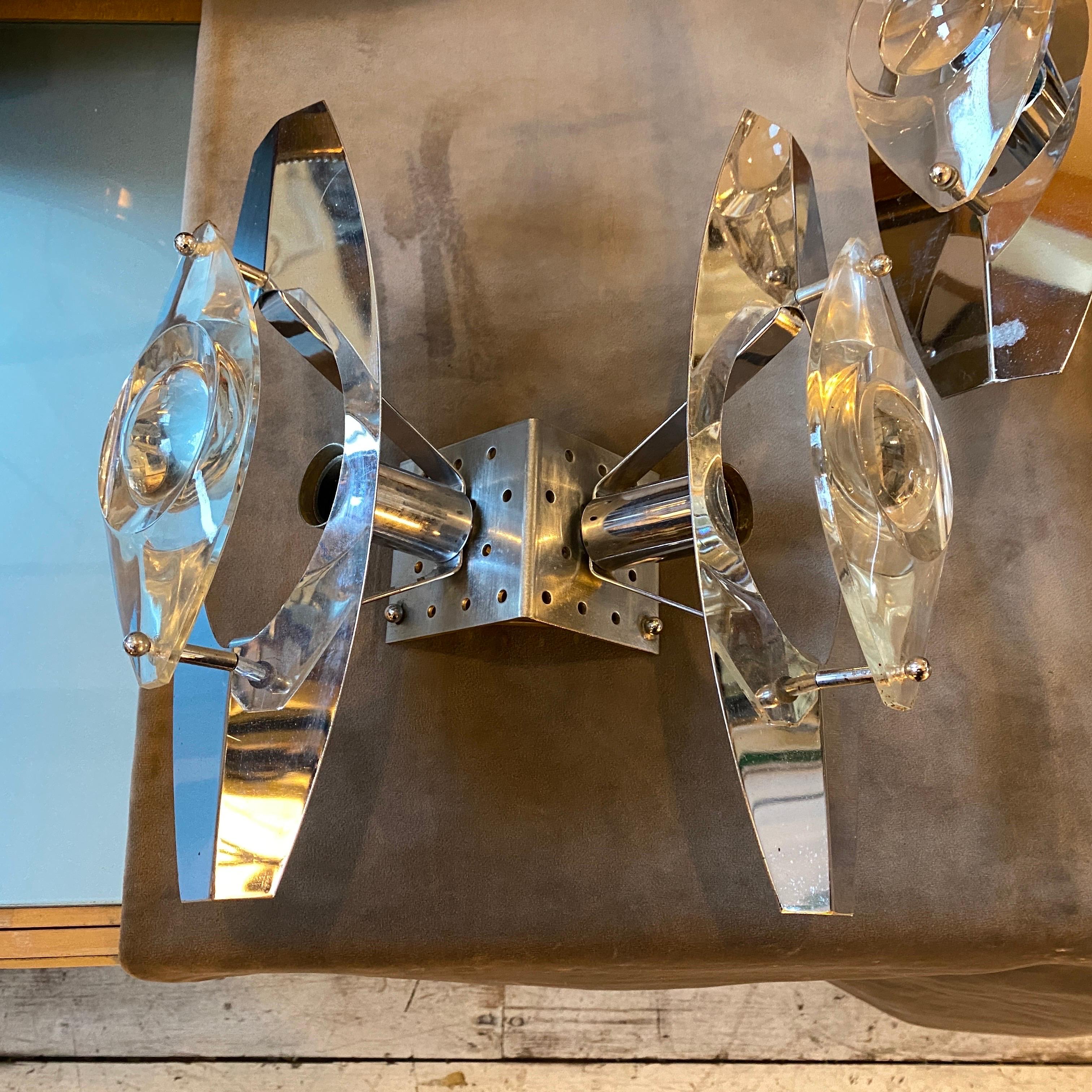 Two exquisite Space Age wall sconces originating from Italy in the Seventies, designed by Oscar Torlasco, are offered in impeccable condition. These sconces are compatible with 110-240 volts and require standard E14 bulbs. Their optical glass