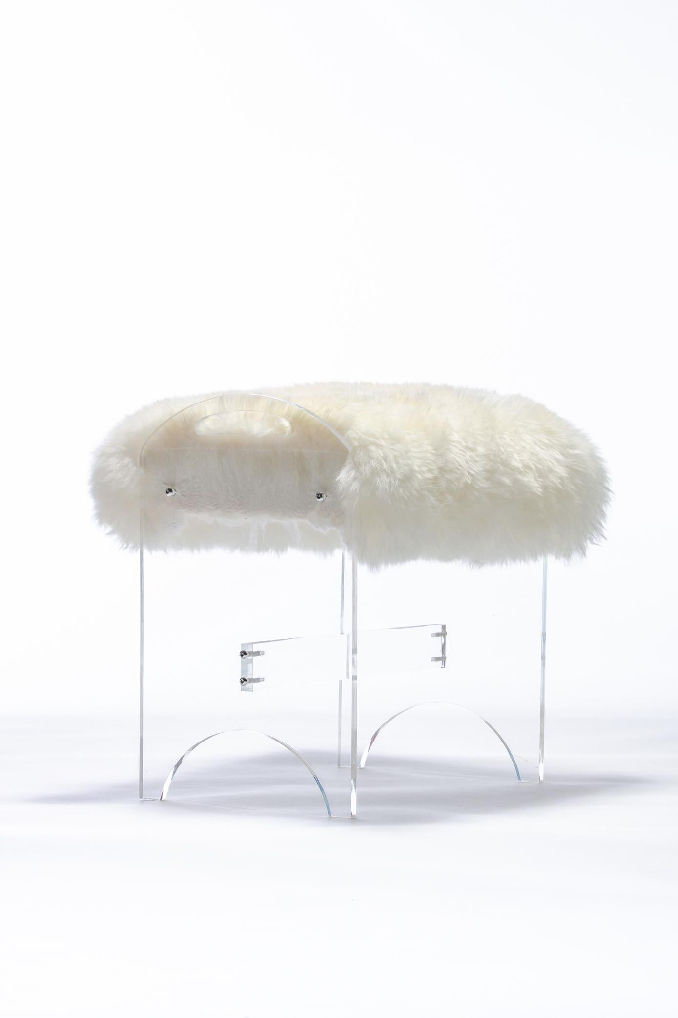 Vanity stool or bench in Lucite with sheepskin upholstery. New upholstery. Clearly chic. This bench / stool could be used with a vanity or as additional seating nested in front of a cocktail table or in a walk in closet to sit to put your shoes on.