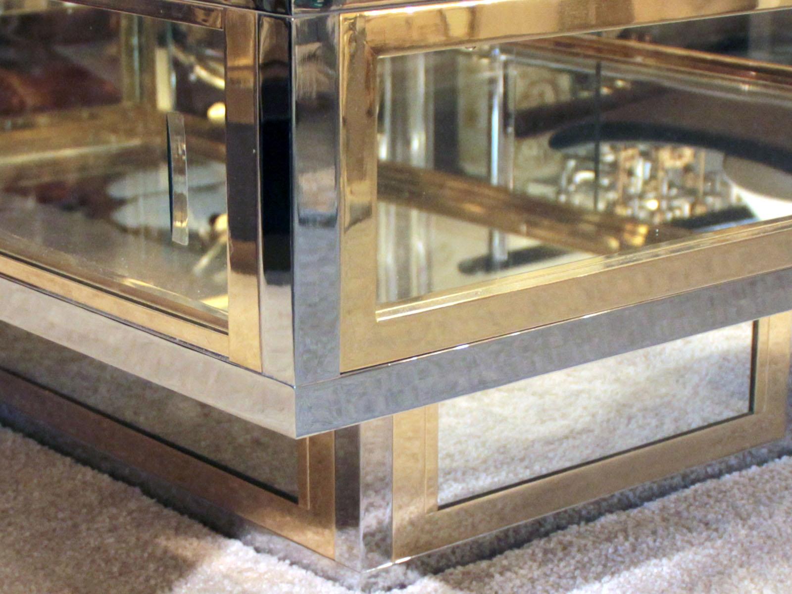 1970s showcase coffee table in the taste of Romeo Rega, in chrome, polished brass and clear glass, with two sliding glass sides.
The bottom of the showcase is in mirror.