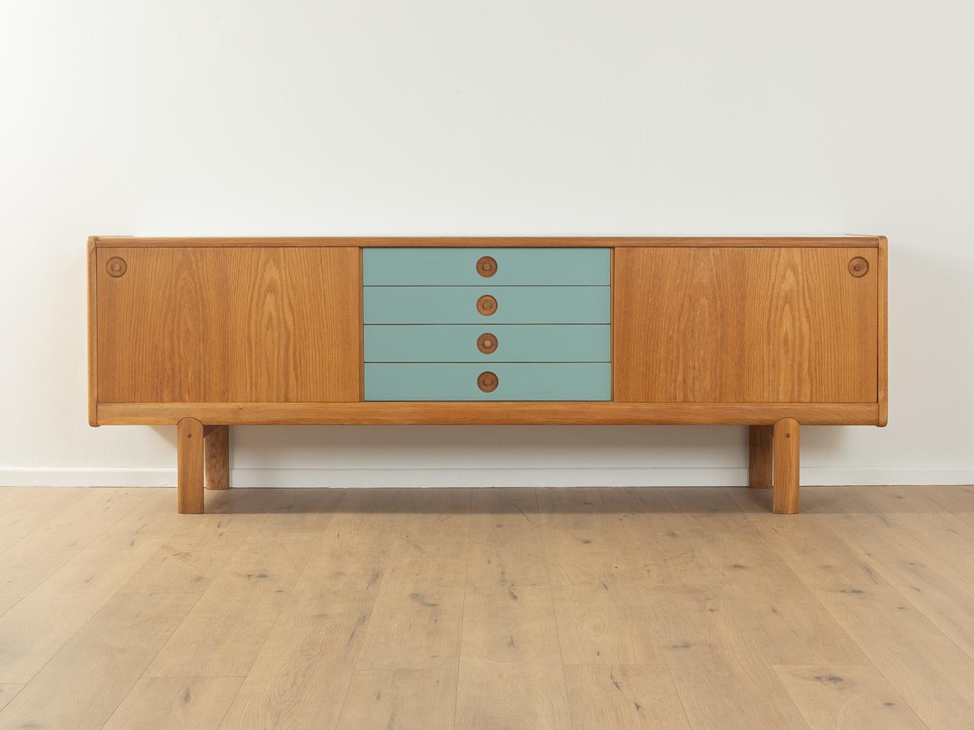 Credenza classica degli anni '1970 di H. W. A. Klein per Bramin. Corpo di alta qualità impiallacciato in Oak con quattro cassetti rivestiti in Formica di colore grigio blu, due ante scorrevoli, due ripiani e piedi in legno massiccio. Il piano è