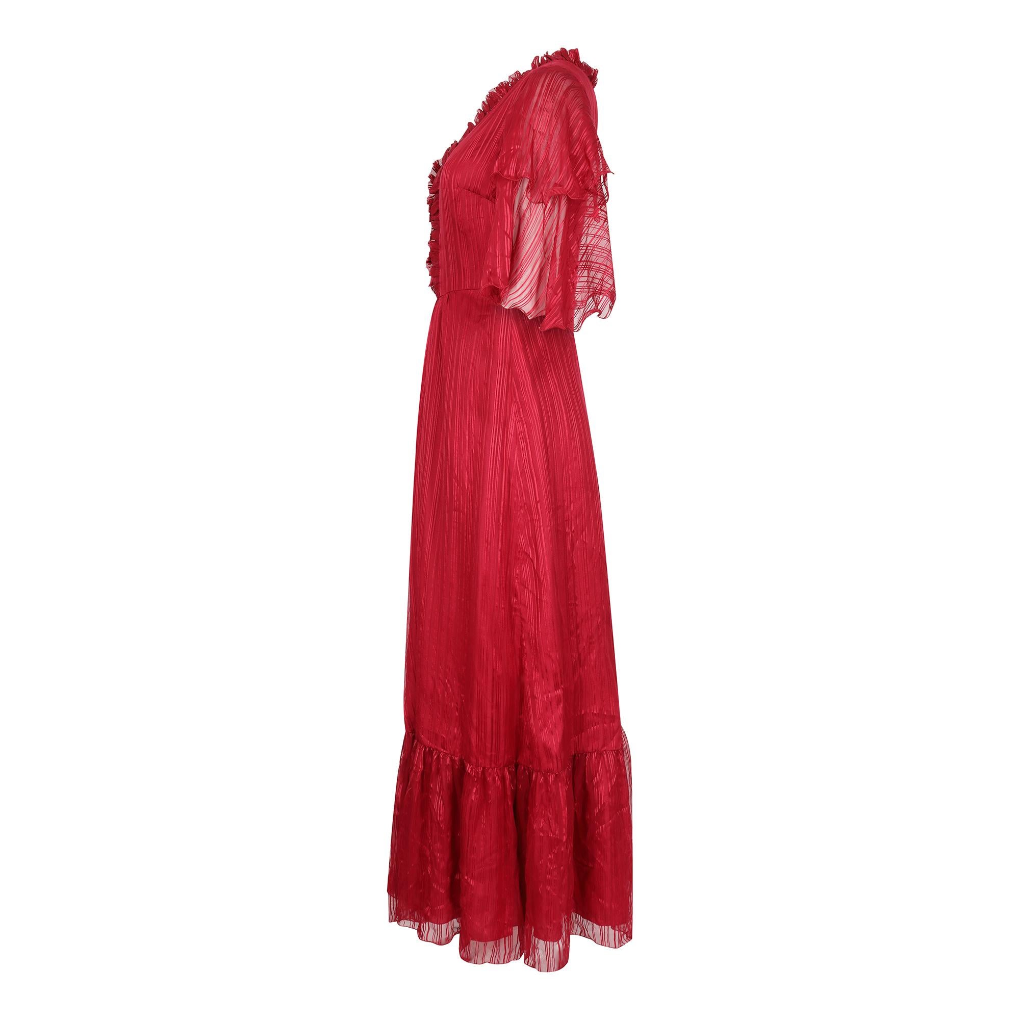 This is a superb example of 1970s lux Victoriana fashion and has many high end couture elements and tailoring. The dress is made of the finest scarlet red silk chiffon in contrasting ribbon bands and the design is synonymous with the long flowing