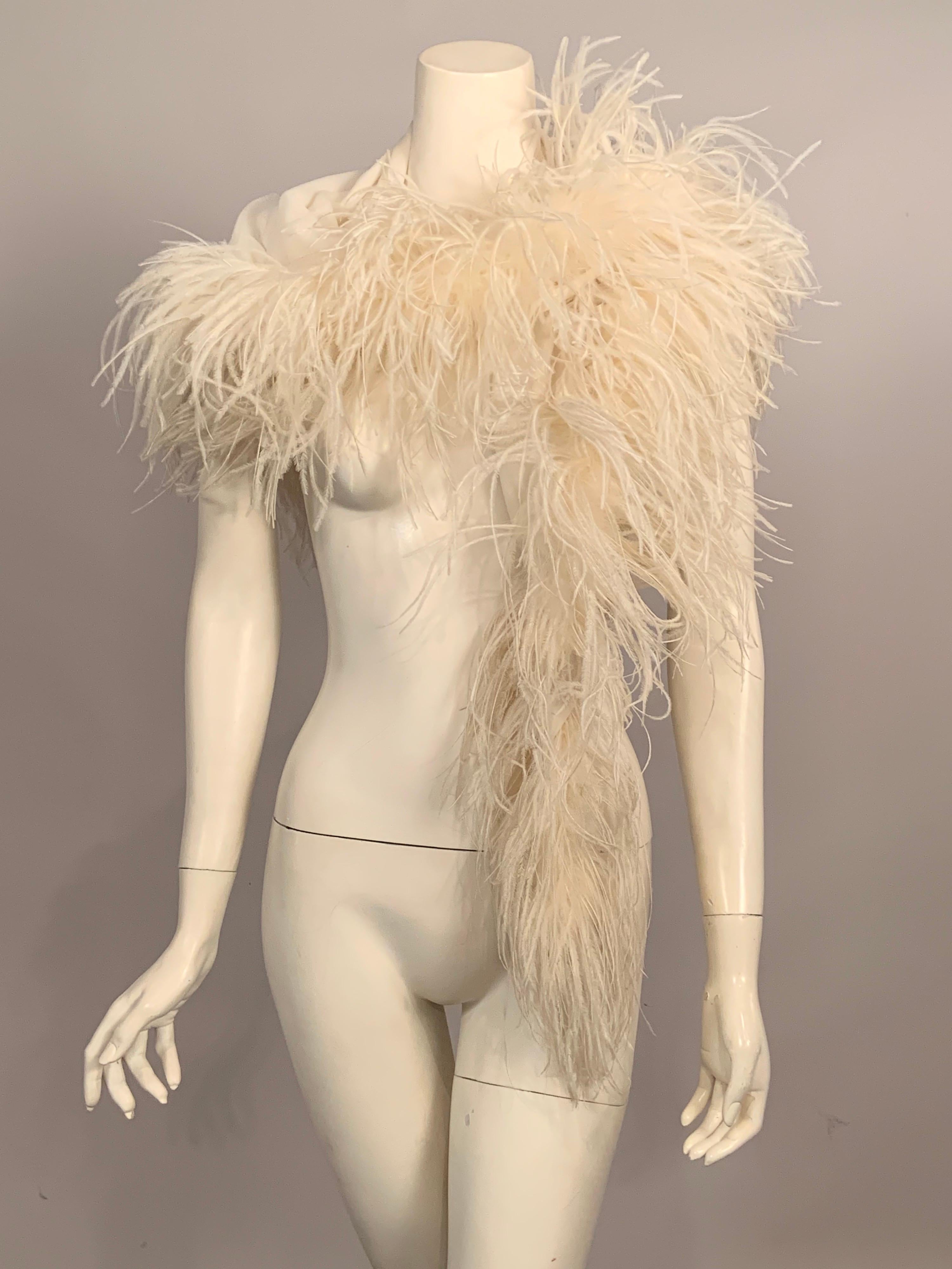 This stunning silk crepe shawl is trimmed with lush white ostrich feathers and it can also be worn as a hip wrap.
A double layer of silk chiffon is used to form this triangular shawl edged in matching cream ostrich feathers on two sides.  A Lord &