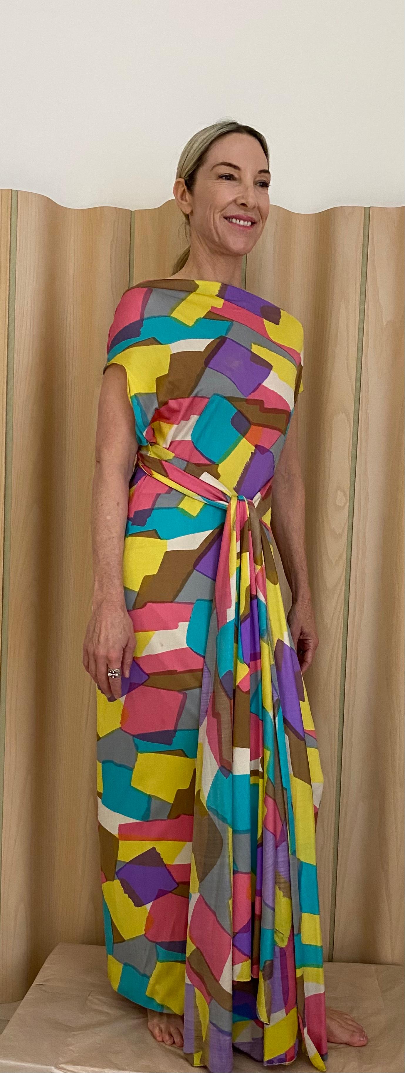 1970s Multi Color ( purple, pink, blue , and yellow ) abstract print silk jersey dress with long sash. 
Dress can be worn 2 way see pictures attached. You can style it as Halter dress with long sash hang at the back and you can wear it the other