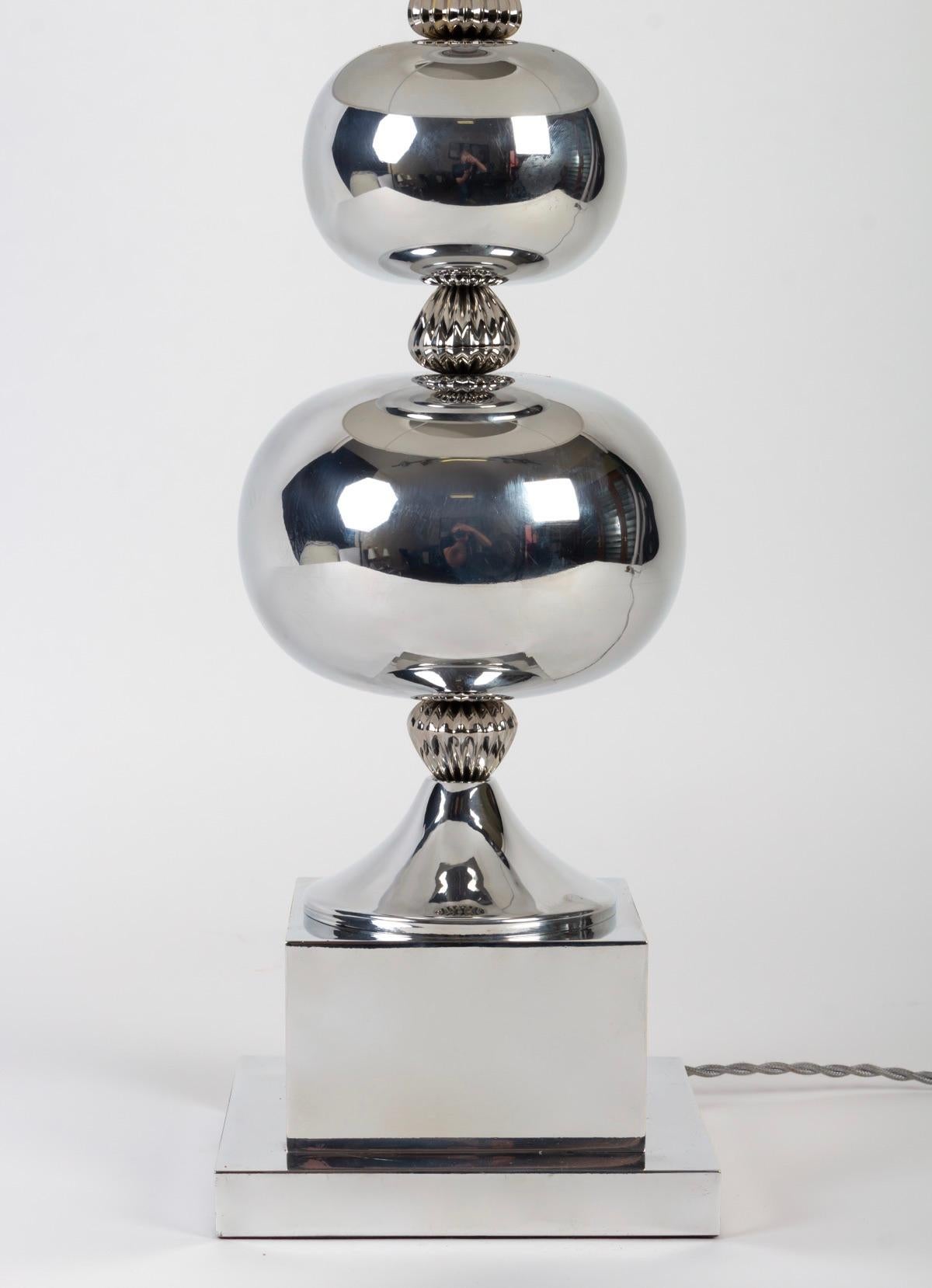 Élégante lampe à boules argentées fabriquée dans les années 1970. P. Barbier

Composé d'une base de section carrée surmontée d'un cube sur lequel est positionné un pied de douche.
Au sommet de la base de la douche, deux boules argentées de tailles