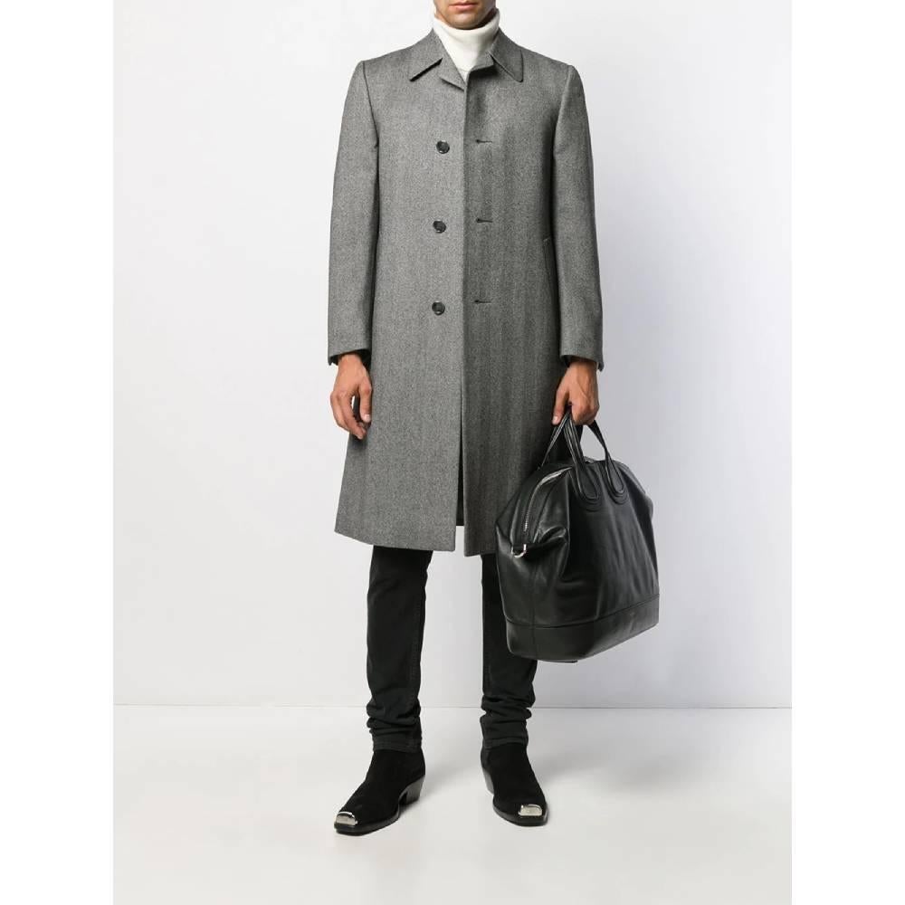 Simon Ackerman grey wool herringbone knee-length coat, very classy and young. It features a slim fit, a classic collar, a front button fastening, long sleeves, button cuffs, side pockets and a rear central vent. It's fully lined.

Years: 70s

Size:
