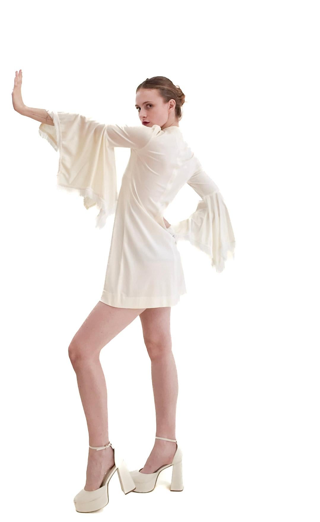 Make a statement at your next event with this 1970's Simon Massey London Mini dress. Perfect for weddings and parties, its fringe and bell sleeves give you the classic 70s look while allowing you to dance the night away.

Measurements:

shoulder: