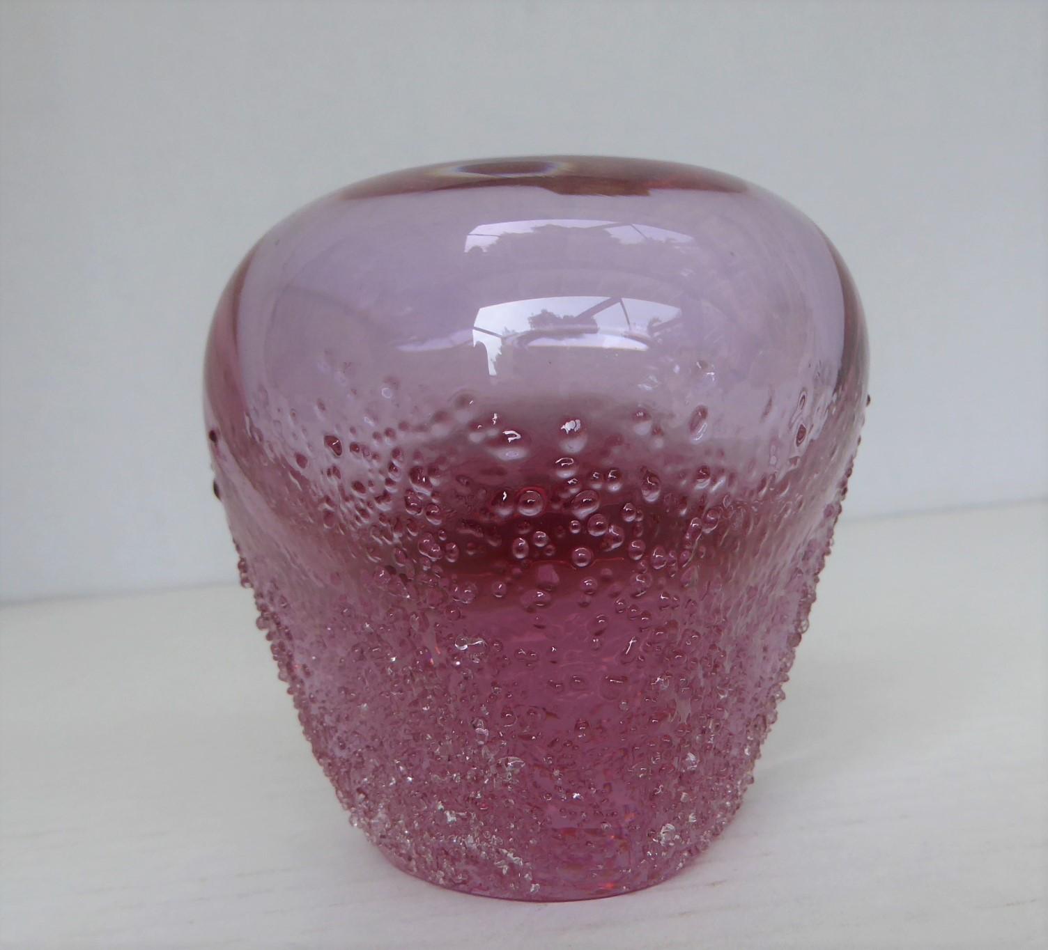 Exceptional Mid-Century Modern pink colored crystal bud vase defined by a highly textured base and a soft and bulbous triangular shape, possibly created by Miloslav Klinger in the 1970s. The bottom half of the small vase has a granular sugar finish