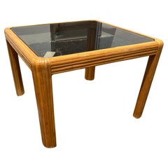 1970 Petite table en rotin avec bord en cascade en verre fumé
