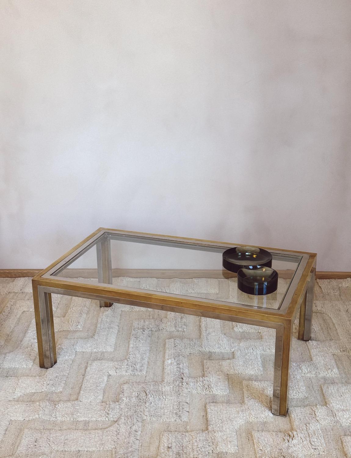 A much sought after Romeo Rega Coffee Table in good condition. This glass topped table has a sturdy chrome and brass base. This iconic design piece is in good condition.