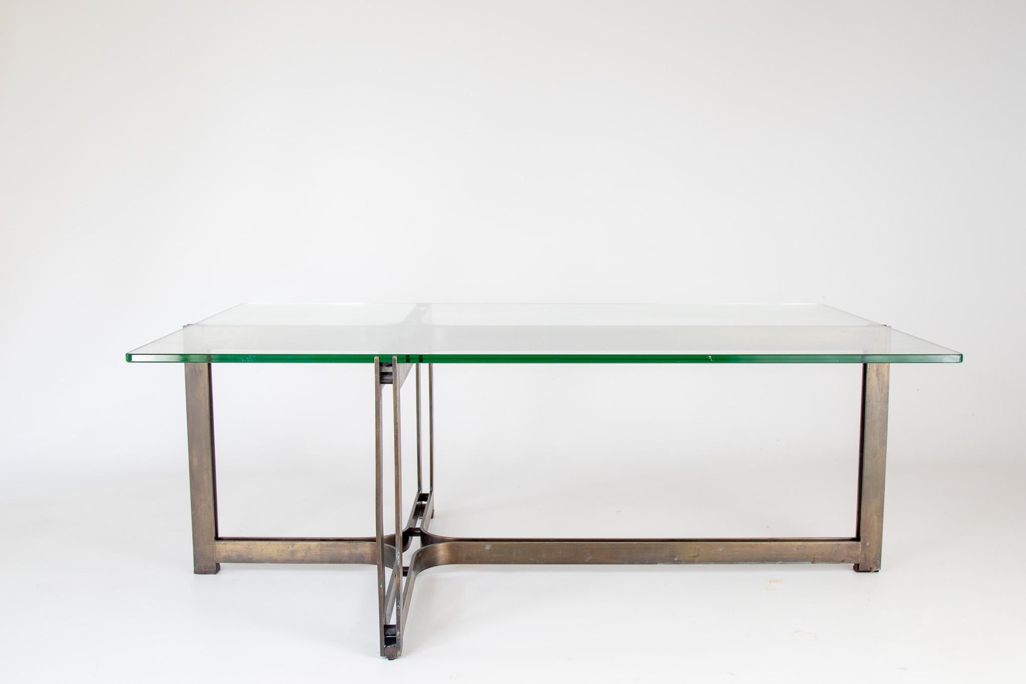 Une table basse en bronze massif à la forme architecturale minimaliste. Conçu par Tom Lopinski pour la société de meubles Dunbar dans les années 1970. Le plateau en verre est d'origine et présente un beau profil vert.  Similaire aux designs de