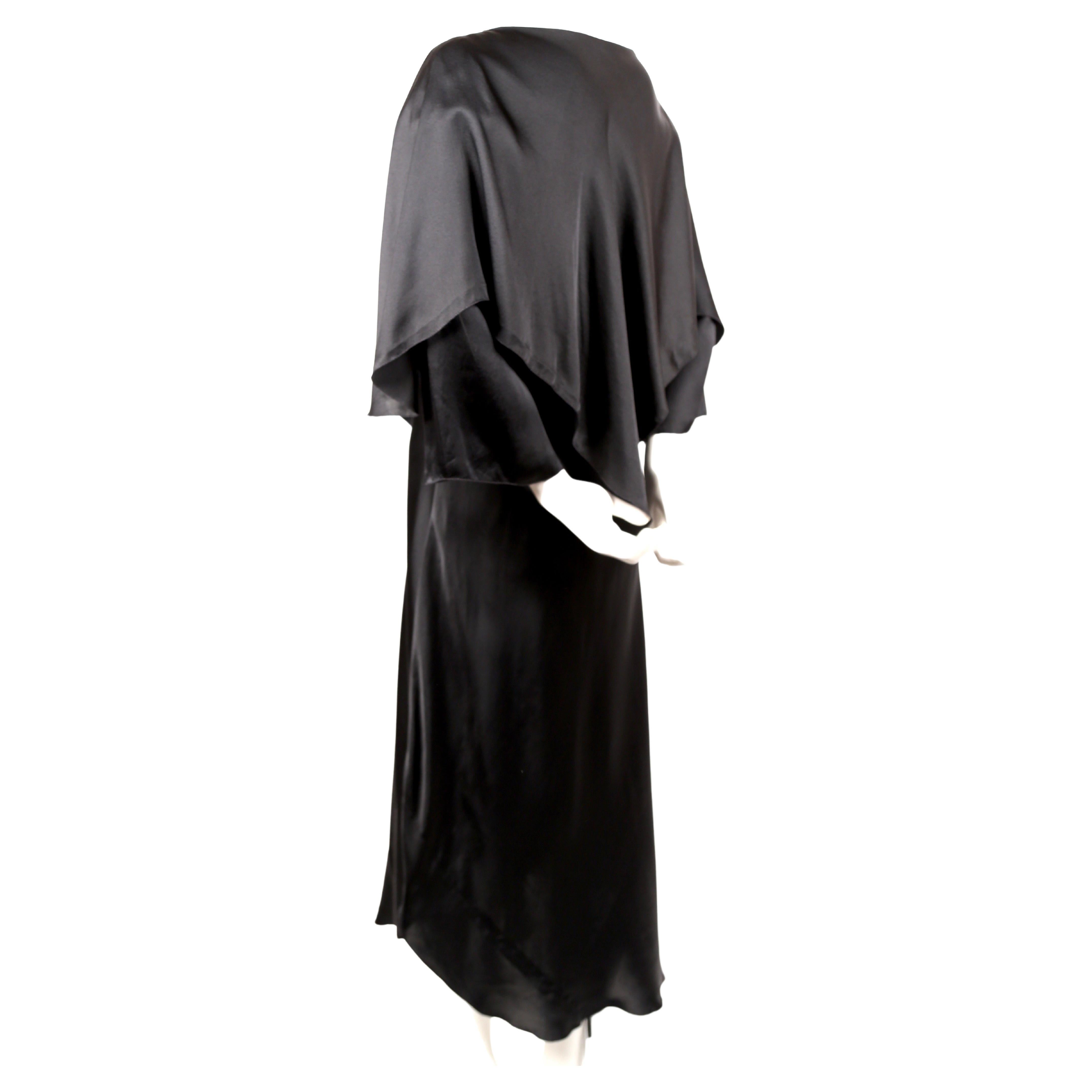 Black, bias-cut silk dress with uneven hemline and cape designed by Sonia Rykiel dating to the 1970's. No size is indicated however this is best suited for a US 2-4. Approximate measurements: 32