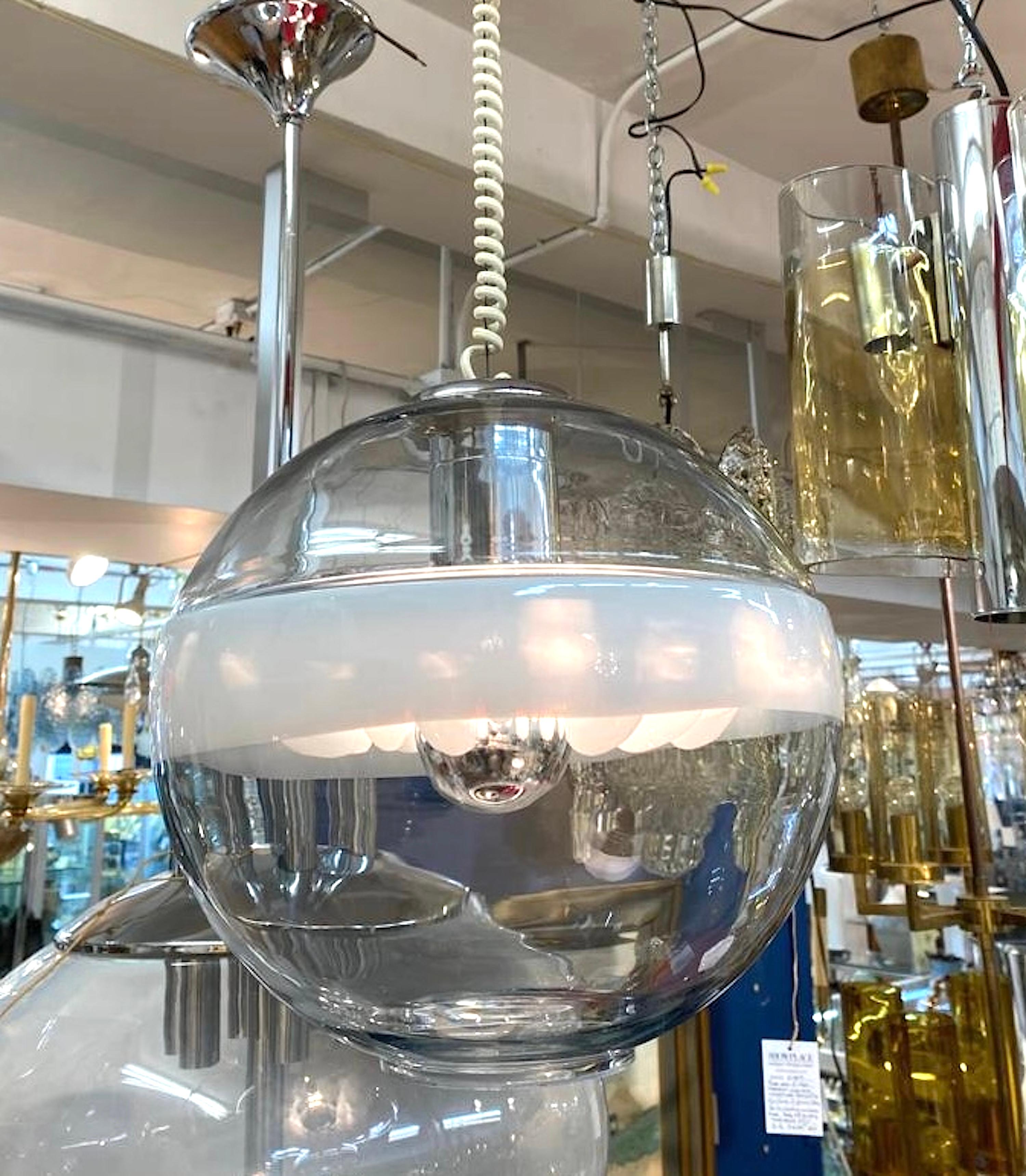 Sculptural 1970s glass pendant light from Murano by Italian lighting company Sothis. The globe shade is hand blown in clear and white glass. Around the middle of the globe is a wide white strip where there is an interior white glass divider all in