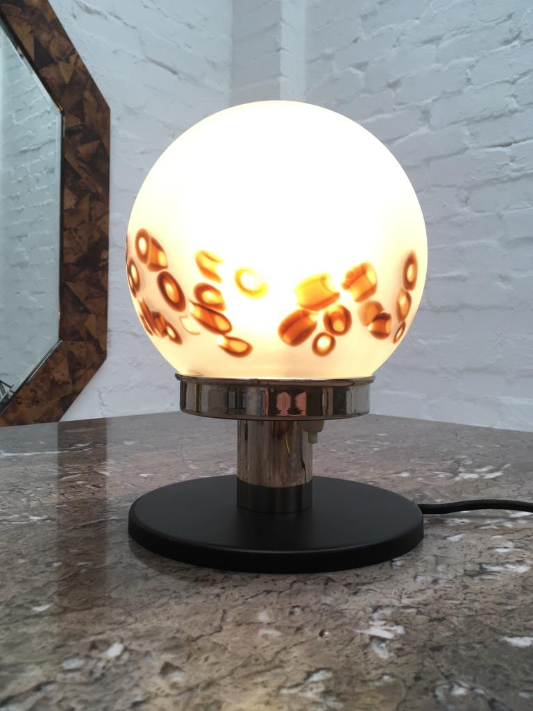 Une lampe de table compacte conçue et fabriquée en Italie ou en Espagne à la fin des années 1970. Nous avons restauré et recâblé, en ajoutant une couche noire satinée à la base. Interrupteur à bouton-poussoir simple situé sous le boîtier en verre.