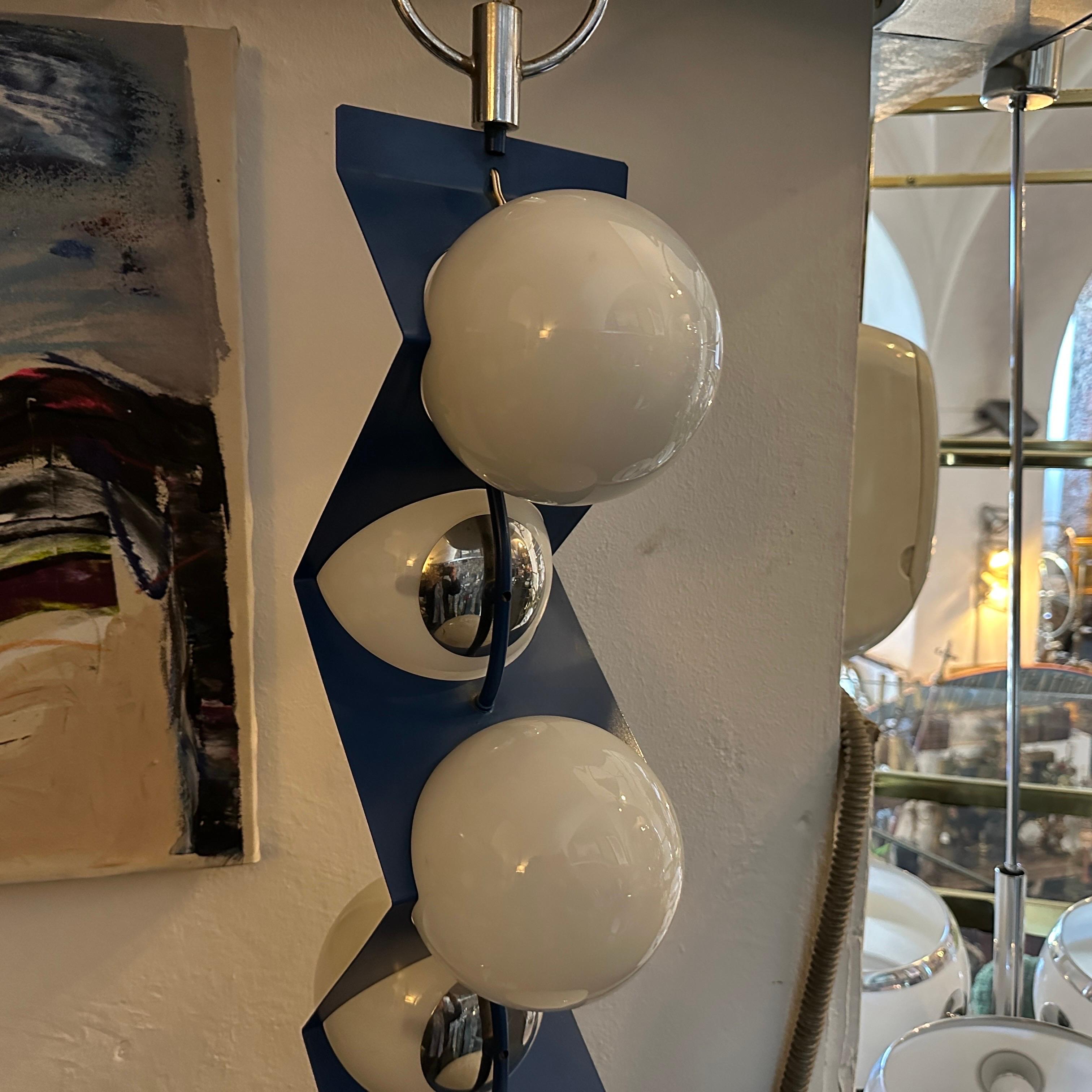 A particular light pendant designed and manufactured in Italy in the Seventies, it's in good condition overall, only a glass has a small flaw covered by the metal part when it's mounted.
The blue hue is vibrant and eye-catching, adding a pop of