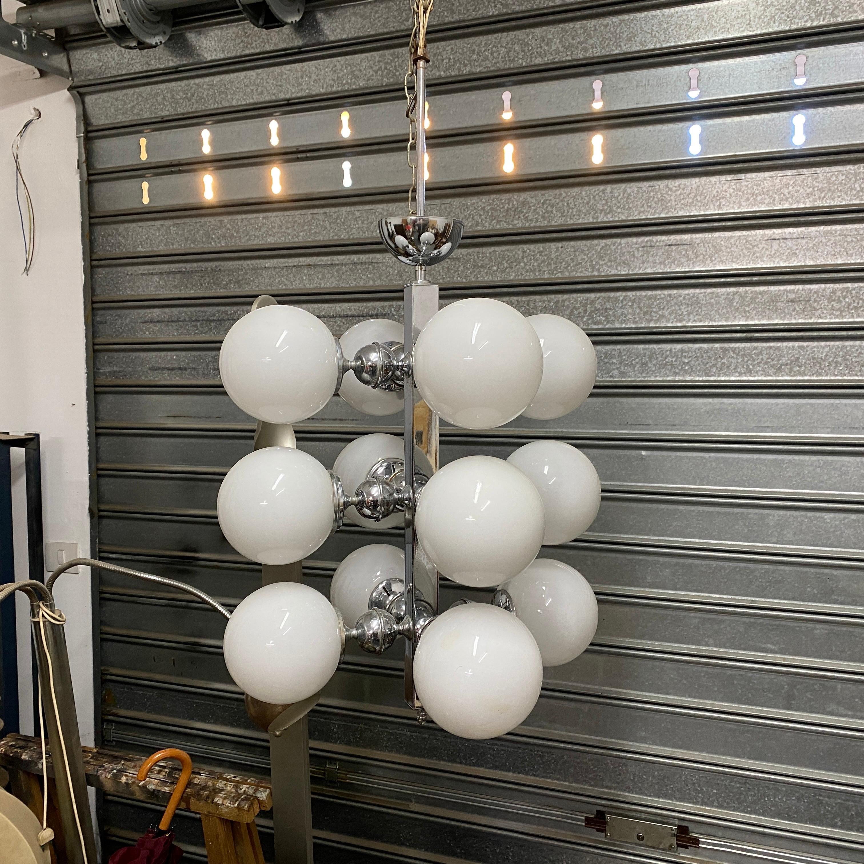 A mid-century twelve lights chandelier made in Italy in the Seventies, it's in good conditions and in working order, it works 110-240 volts and needs twelve regular bulbs.