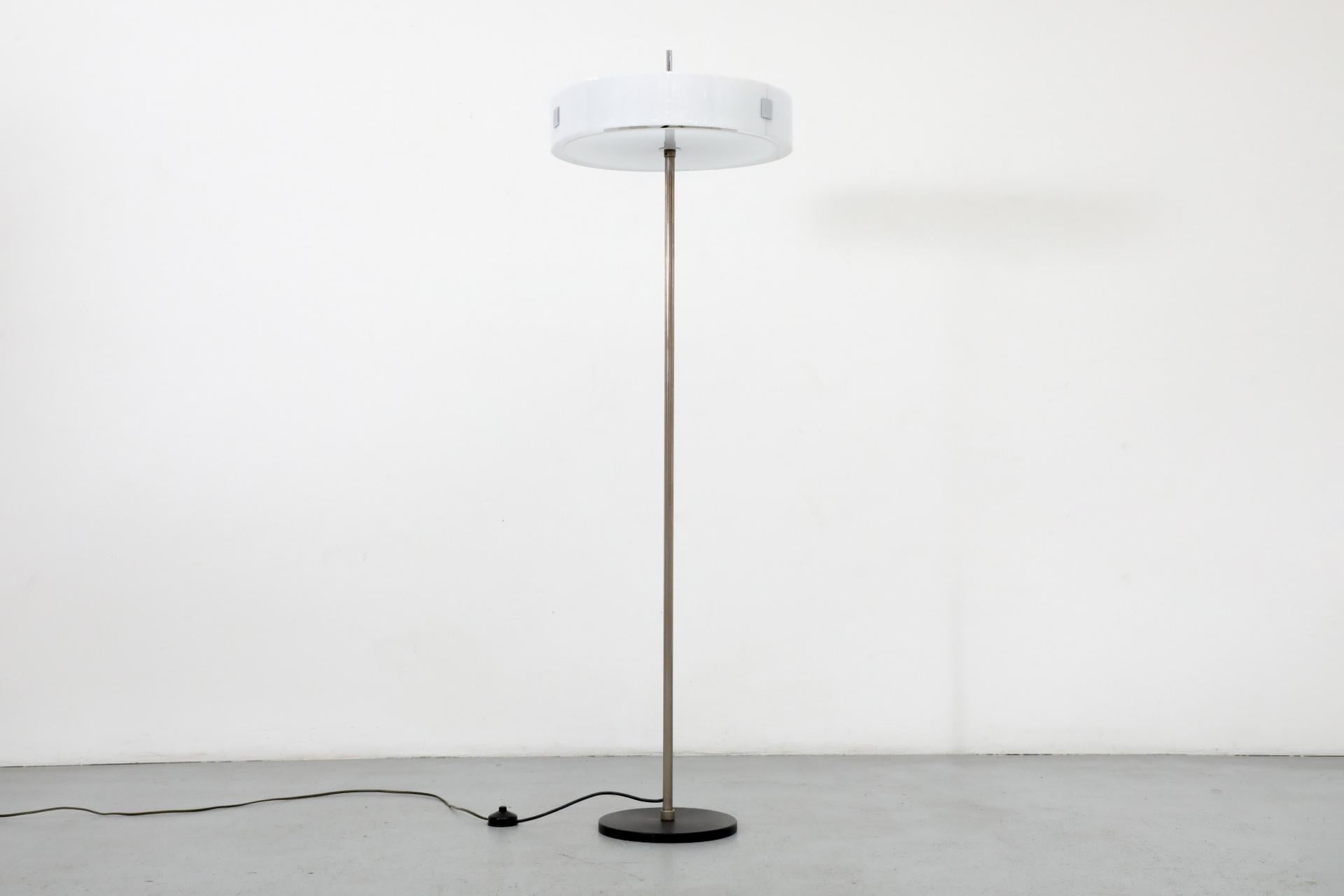 1970s Cosack Leuchte floor lamp with white plexiglass chrome accented disc shade. The stem is also chrome. There is a black enameled disc diffuser on top and a white plexi diffuser under the banded shade, creating off a beautiful ambient light. The