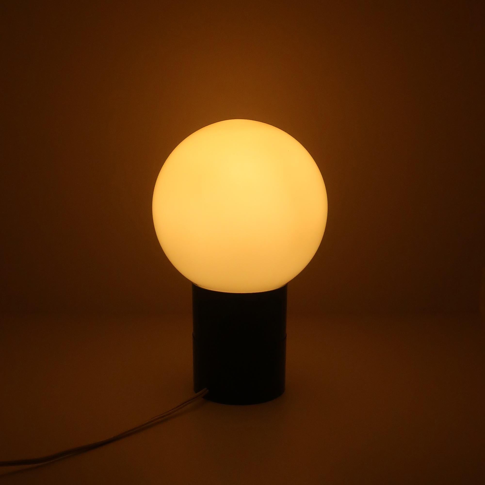 A very cool mid-century modern lamp with a black base and removable frosted glass globe to cover the lightbulb inside.  Takes a regular sized light bulb and on/off switch is on the cord.

In very good vintage condition. 

6