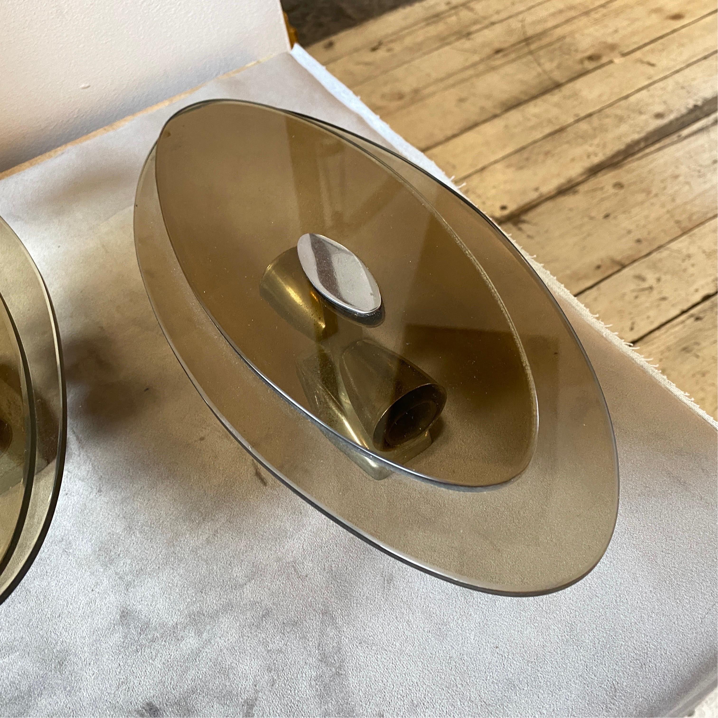 Two big space age wall sconces made in Italy in the Seventies by Veca, they are in very good conditions, they work both 110-240 volts and need regular e 14 bulbs. Smoked glasses are in perfect condition. These Wall Sconces are a striking example of