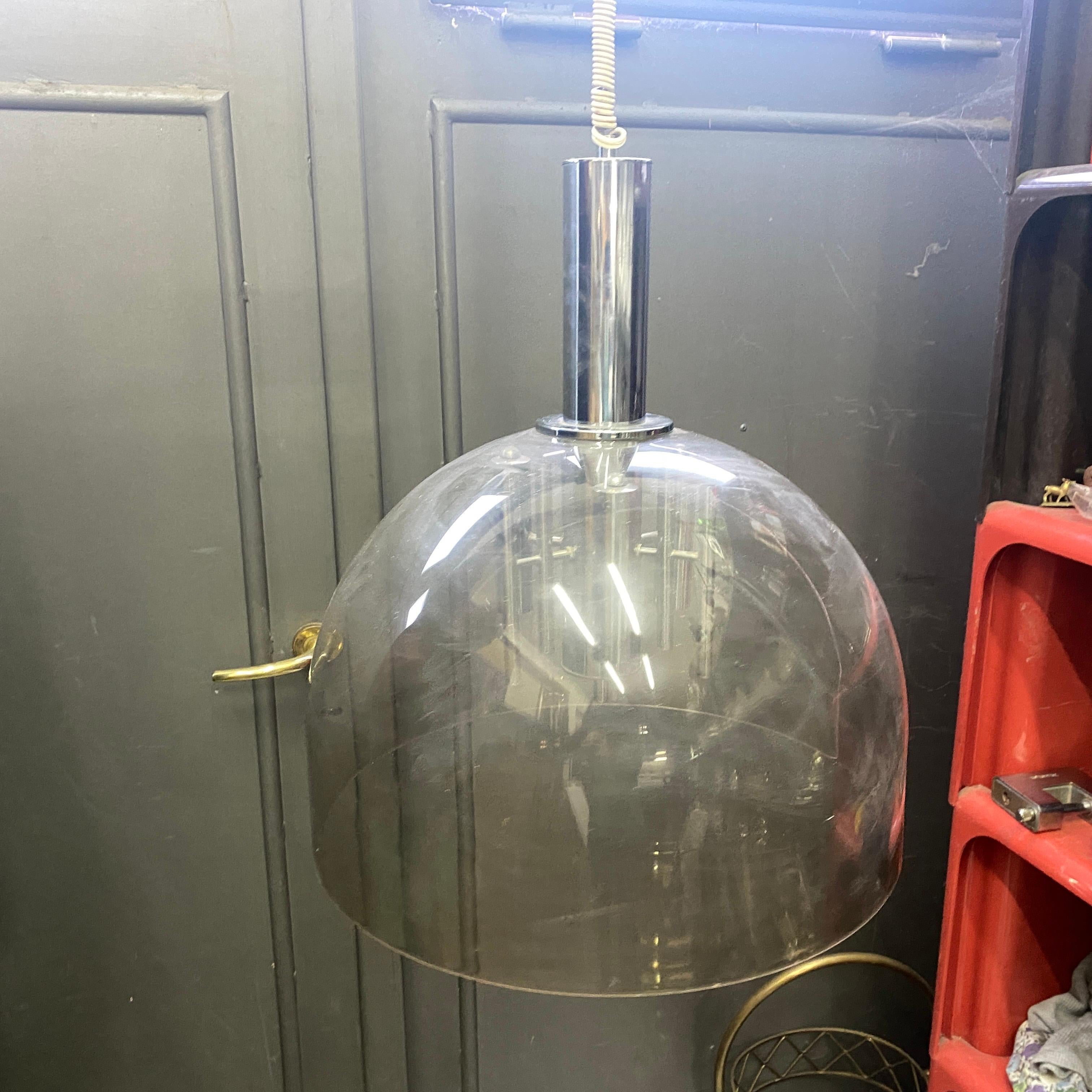A stylish space age pendant designed and manufactured in Italy in the Seventies. Plexiglass and chromed steel are in original conditions. it has normal signs considering use and age. It works both 110, 240 volts and needs regular e 14 bulbs. This