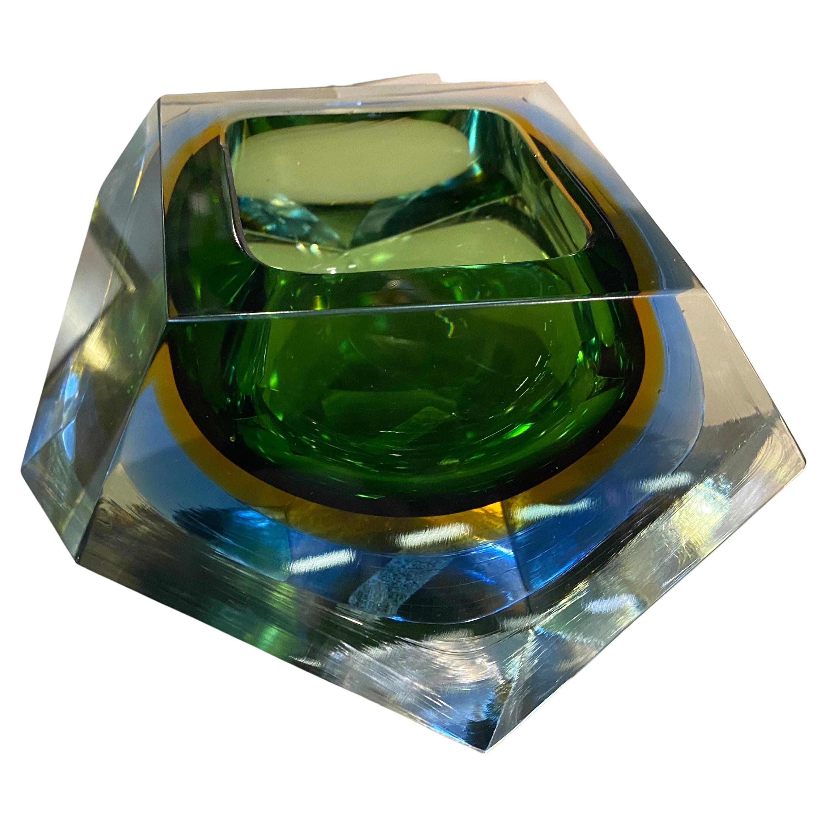 A faceted yellow green and blue murano glass ashtray designed and manufactured in Venice by Seguso. The sommerso technique, It is a decorative technique which, starting from a blown or solid glass, allows to obtain several superimposed layers of