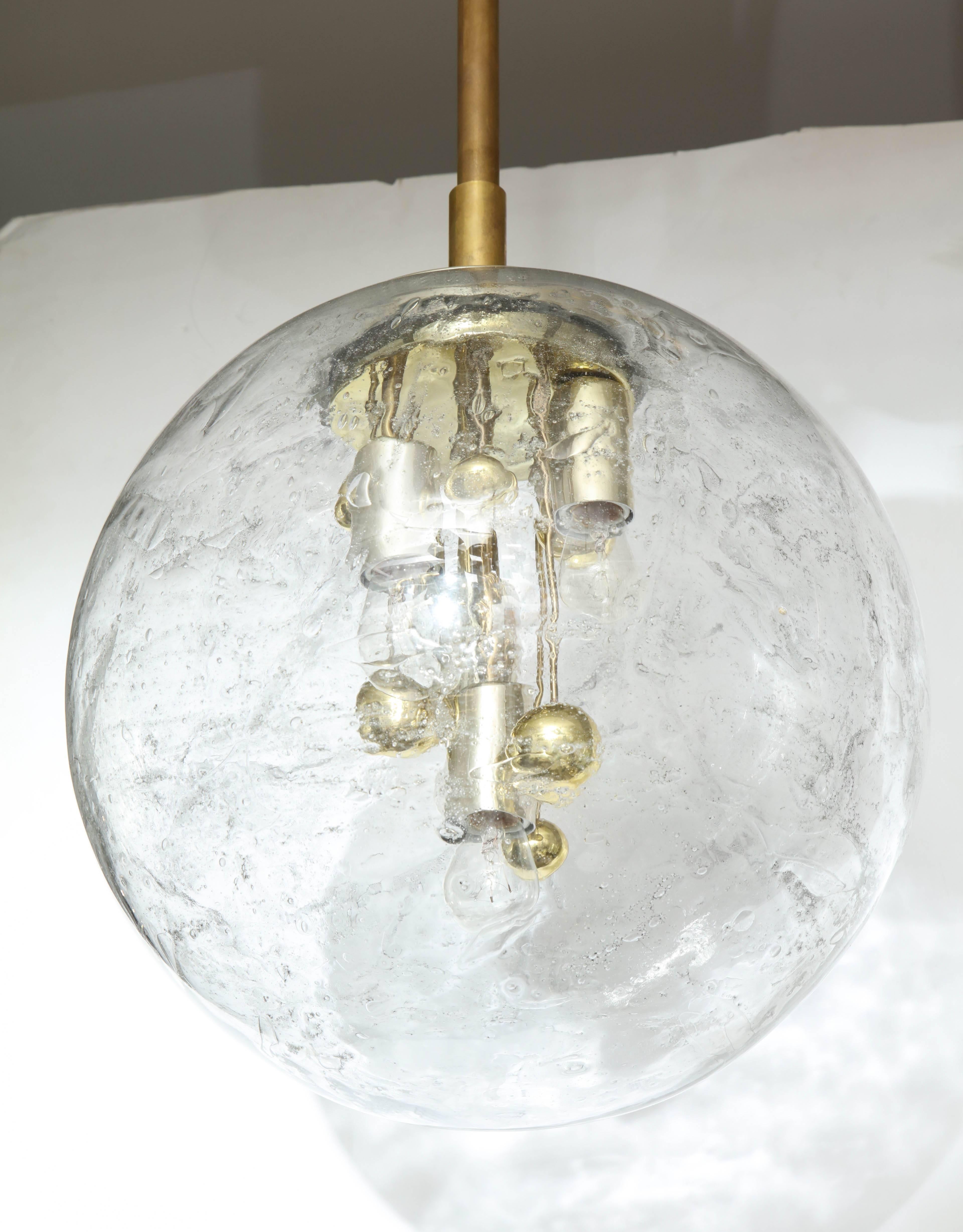 1970s Space Age Sputnik pendant light by Doria.
Amazing large Murano glass globe with a slight veining pattern.
The four light sources which have been newly rewired for the US are complemented by suspended brass spheres. The pendant has a 16