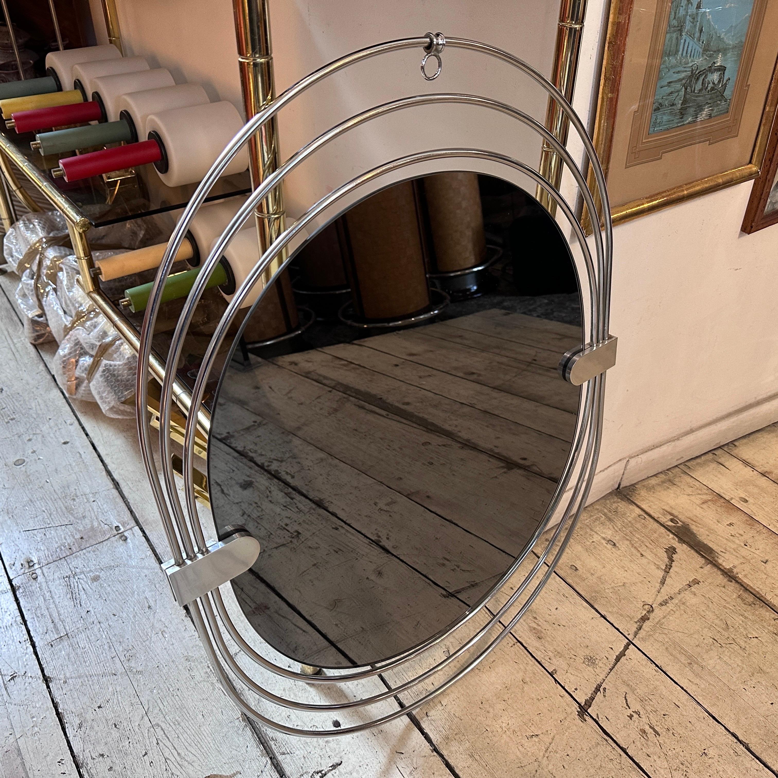 This oval wall mirror, attributed to Gaetano Sciolari and manufactured in Italy in the seventies, is in very good condition. It is a captivating and futuristic piece that embodies the iconic design of the Space Age era. This wall mirror showcases a