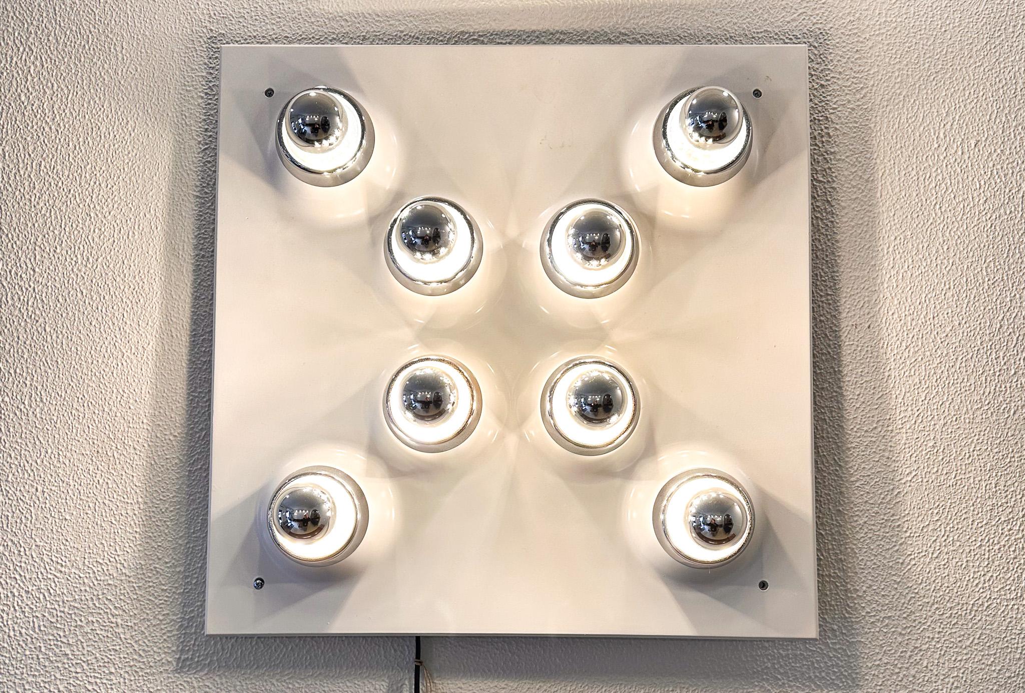 This is a vintage wall lamp reminiscent of the Space Age aesthetic popular in the 1970s. It features nine spherical, chrome-plated lights arranged in a uniform, organic cluster, which gives it a playful yet modern look. Each sphere is mounted on a