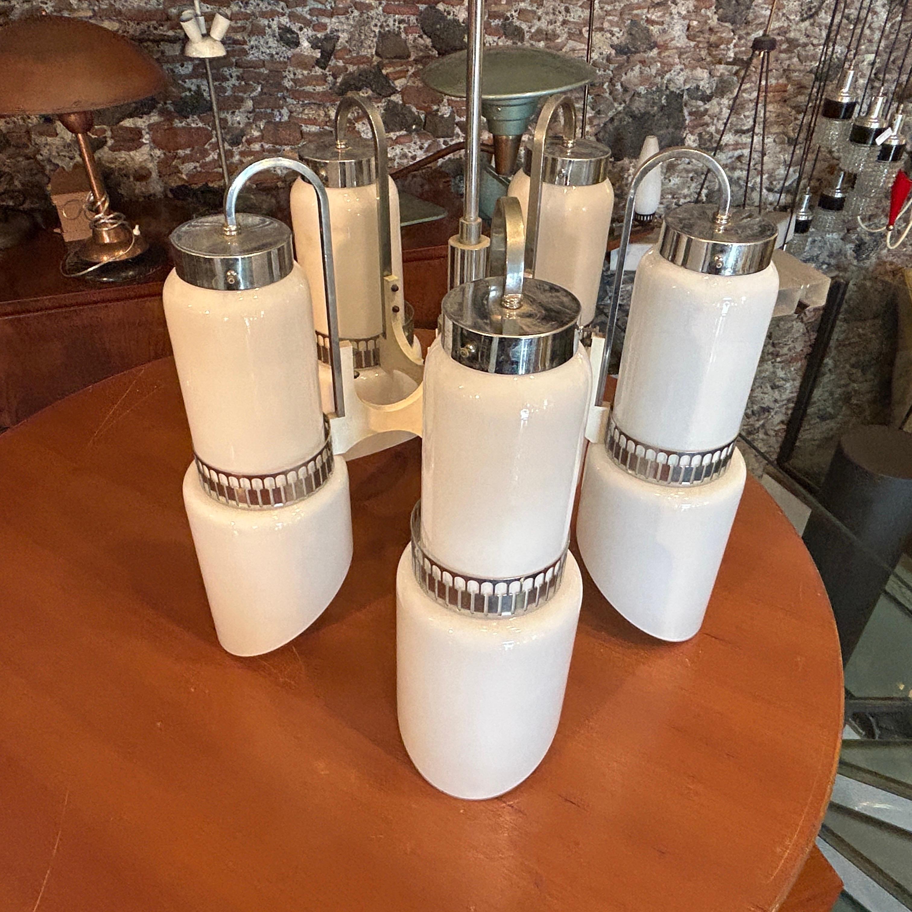 A white painted wood, steel, and white glass chandelier designed by Gaetano Sciolari during the Space Age era is offered in excellent condition and is fully operational. The fixture features five large white opaline glass diffusers that create a