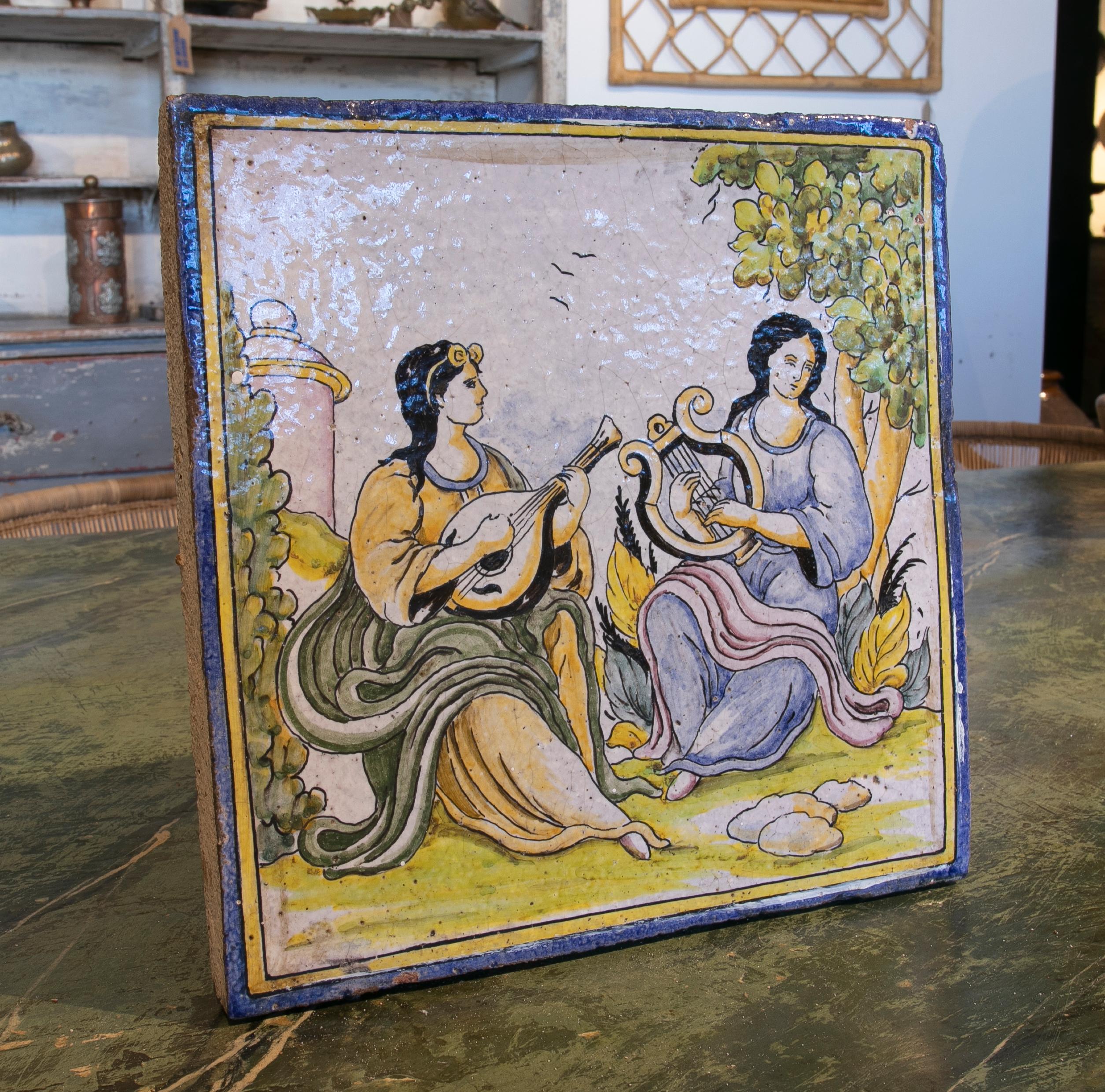 Carreau de céramique émaillée espagnol des années 1970, peint à la main, avec une scène de personnages.