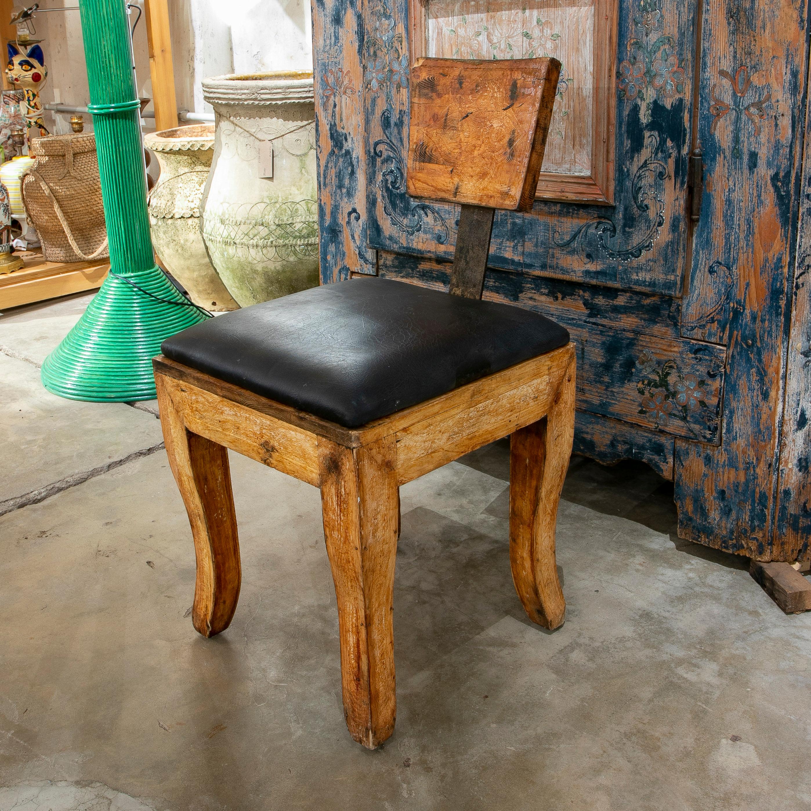 spanischer Designerstuhl aus Holz und Eisen aus den 1970er Jahren mit einer unverhältnismäßig kleinen Rückenlehne und einem rauen, verwitterten Industriecharakter, der ihn auszeichnet.
 