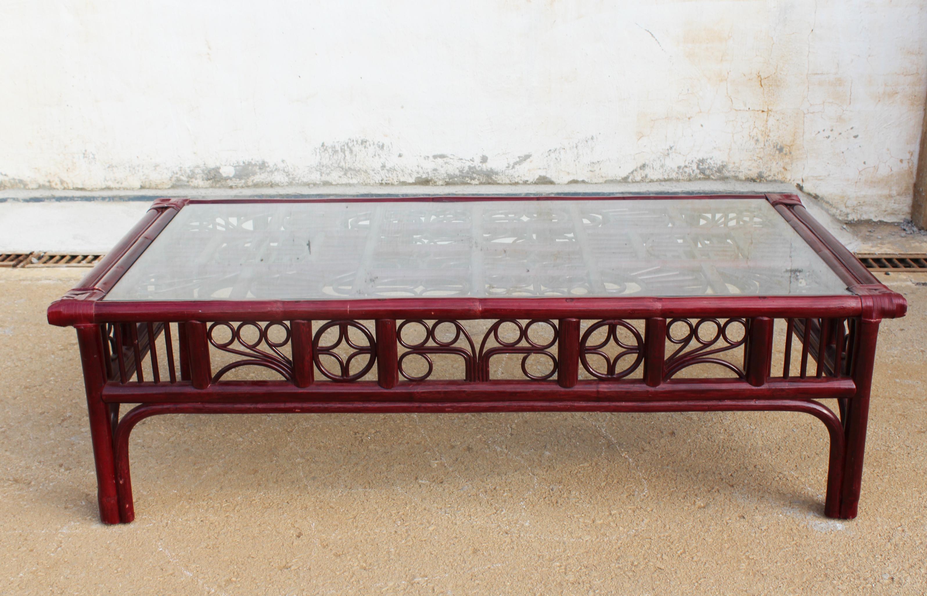 1970s Spanish red wood imitating cane bamboo rectangular coffee table set with leather binds, glass top, and decorated with geometric Orientalist motifs.
  
