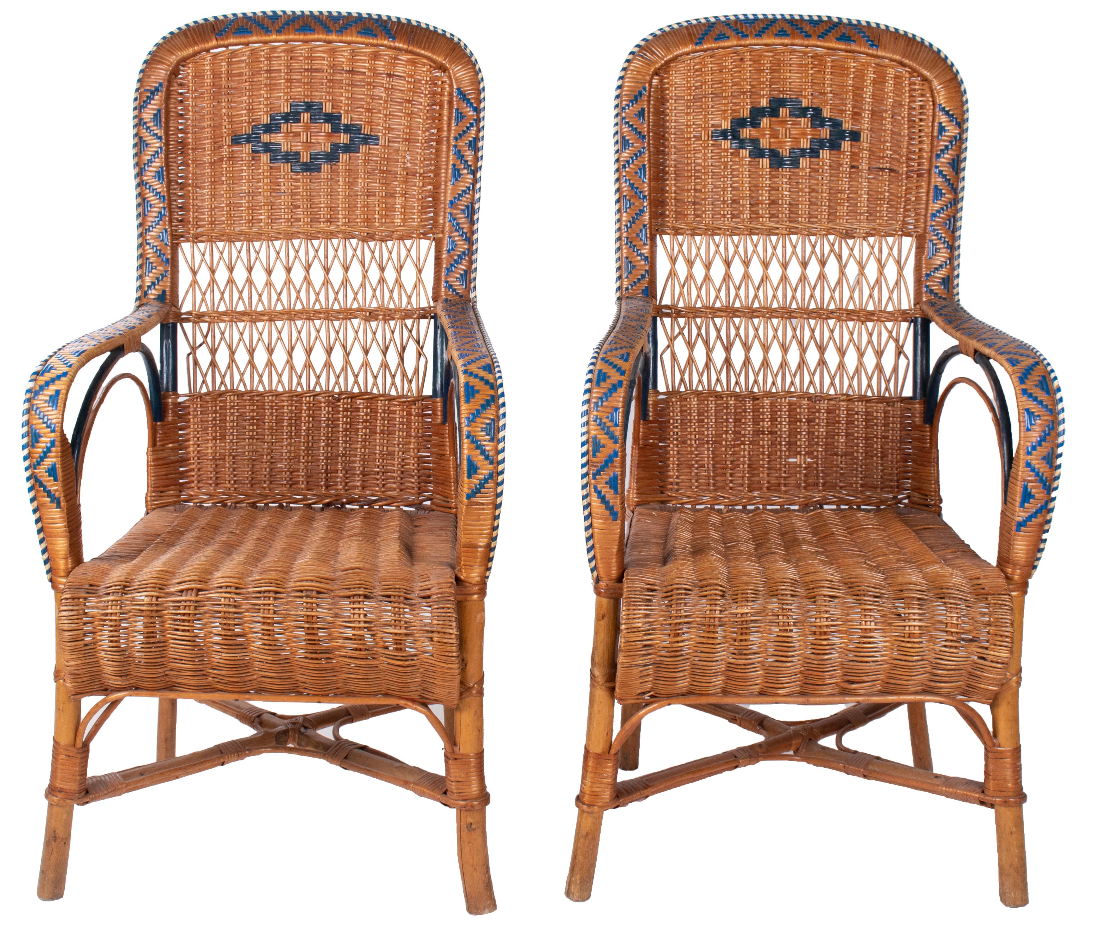 1970s Spanish pair of wicker and wood armchairs, decorated with geometric motifs using colourful stained wicker, particularly on back and armrests.